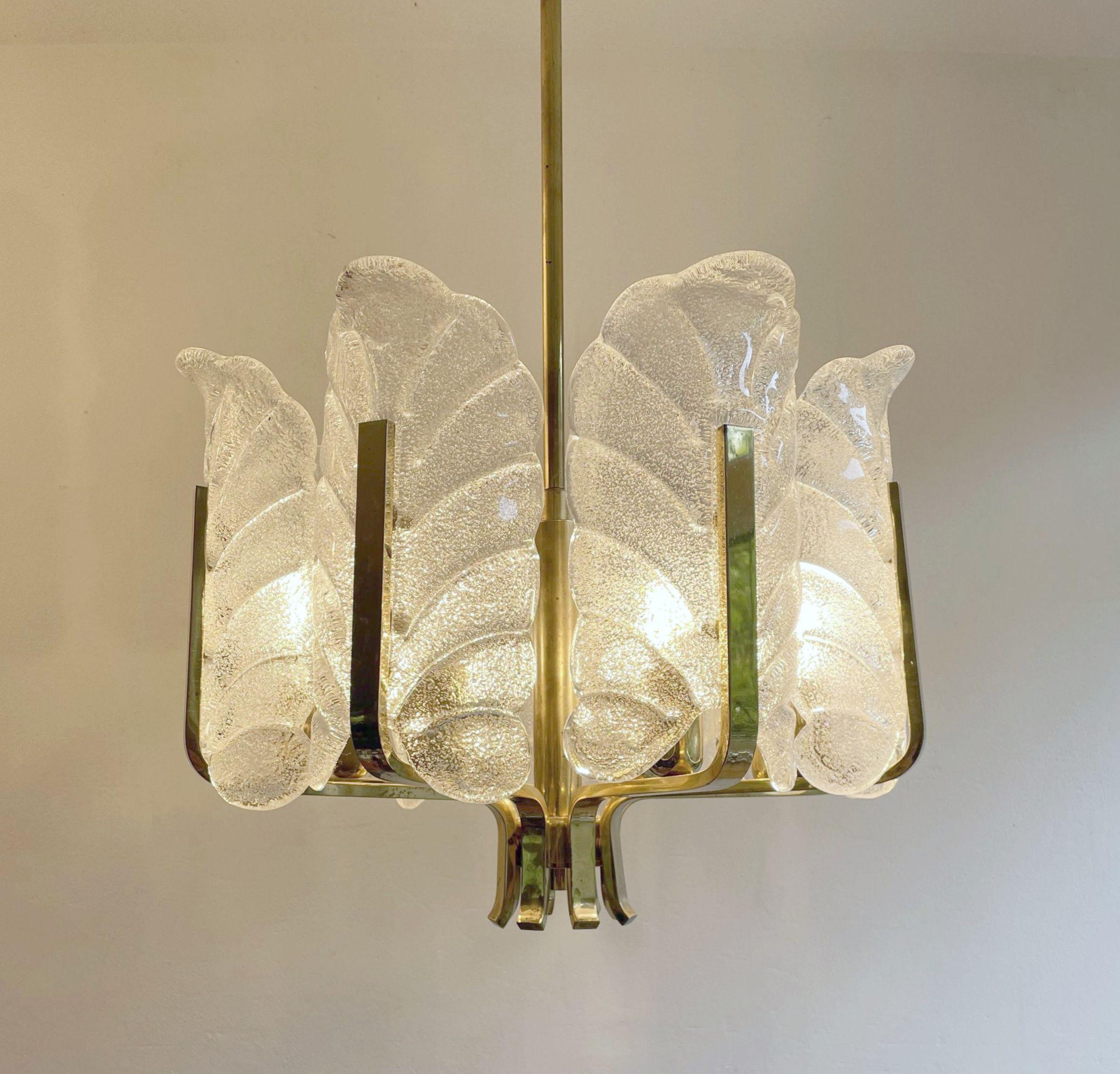 Lampadario in ottone di stile Mid-Century Modern realizzato negli anni '70. Ha bracci in ottone, ciascuno con un paralume in vetro ghiaccio a forma di foglia. La lampada viene spesso attribuita a Carl Fagerlund per via delle somiglianze nel design.