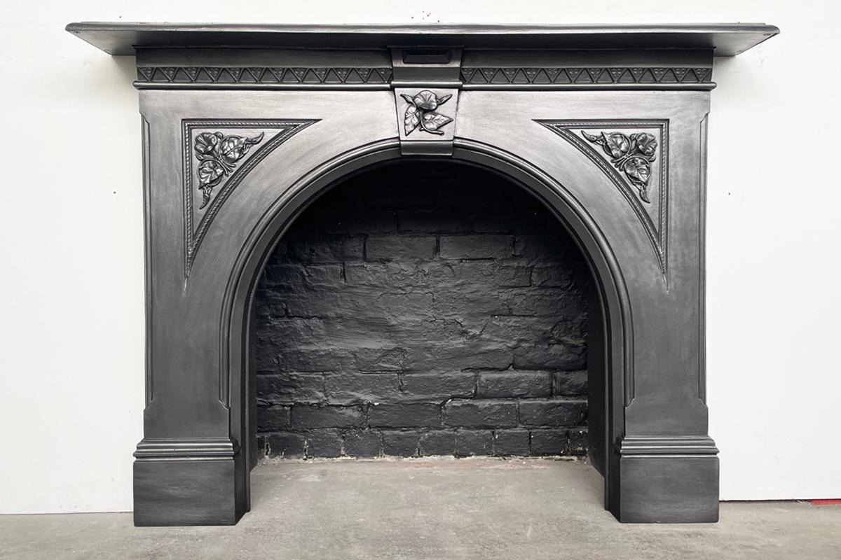 Large and impressive original Victorian cast iron fireplace surround with an arched aperture and high relief floral castings to the spandrels and keystone. Circa 1860.

Finished in traditional black grate polish.

For detailed sizes see the size