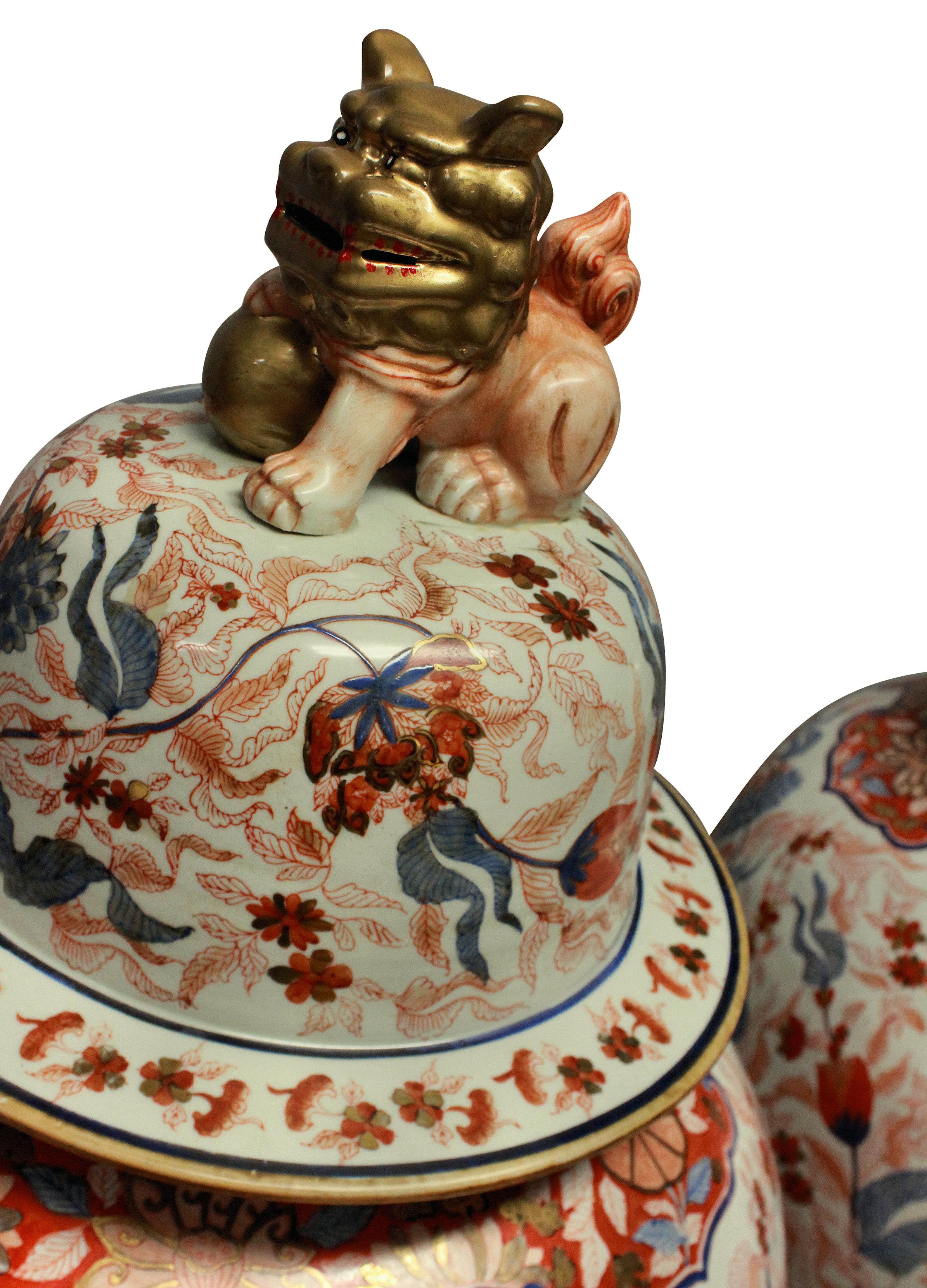 A large and impressive pair of Japanese Imari floor vases with covers. Decorated by hand in the traditional palette of cobalt blue with iron red and ground gold. The covers have dogs of foo finials. The vases are unusual in their scale. They are
