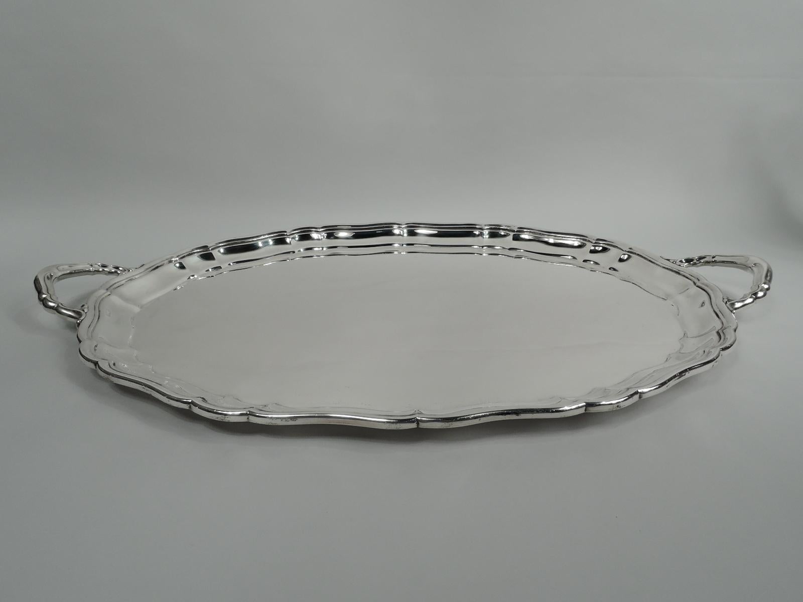 Large and old-fashioned American sterling silver tea tray, 1954. Retailed by Cartier in New York. Oval well and scrolled sides and rim; end bracket handles. Fully marked including retailer’s stamp, Gorham date code, and no. 207. Heavy weight: 132