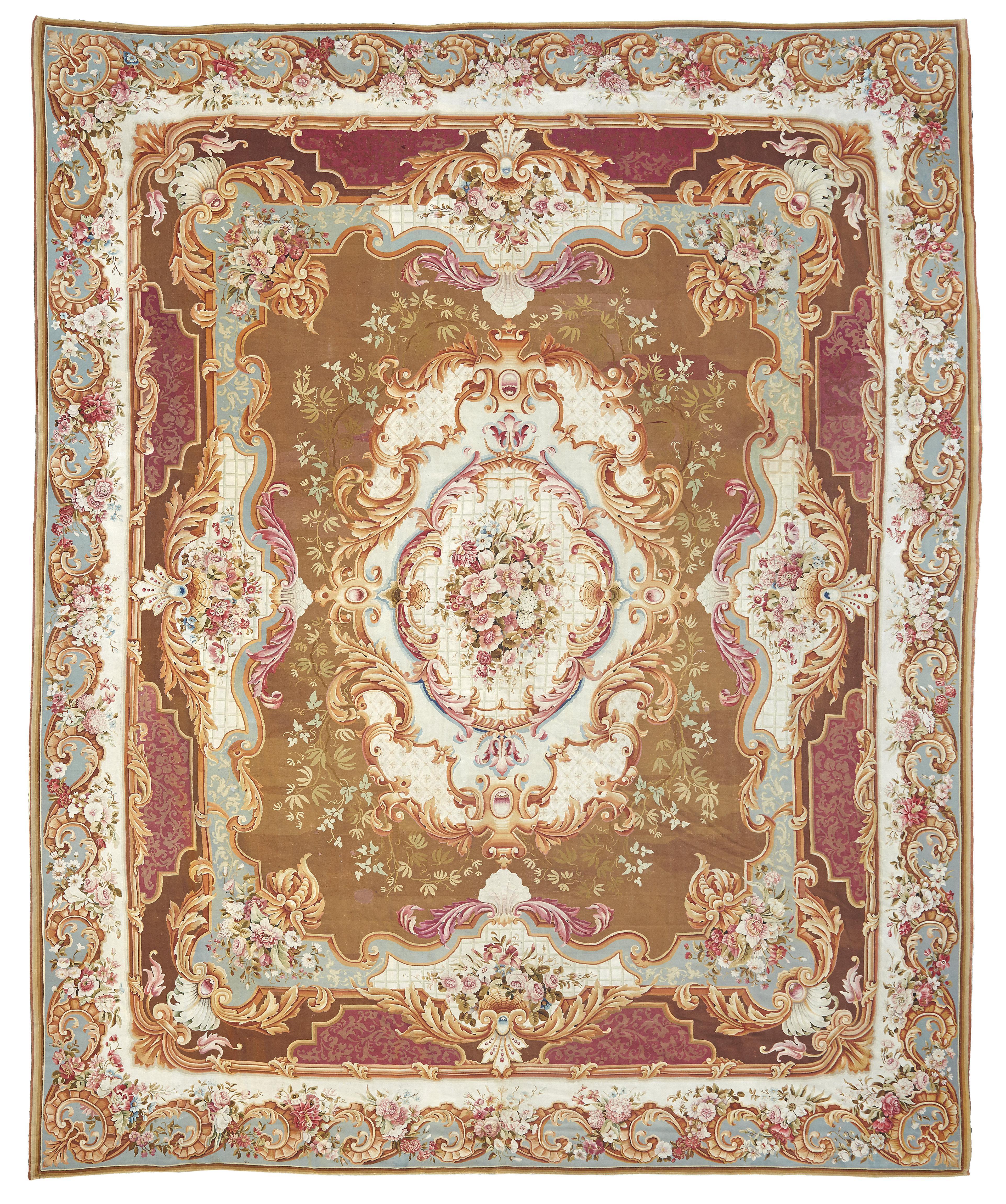 A monumental 19th century French palace size handwoven Aubusson rug. The classical rectangular rug presents with crisp detailing and deep coloration in Beige, Brown, Maroon, and Teal. The central medallion with a floral bouquet within foliate
