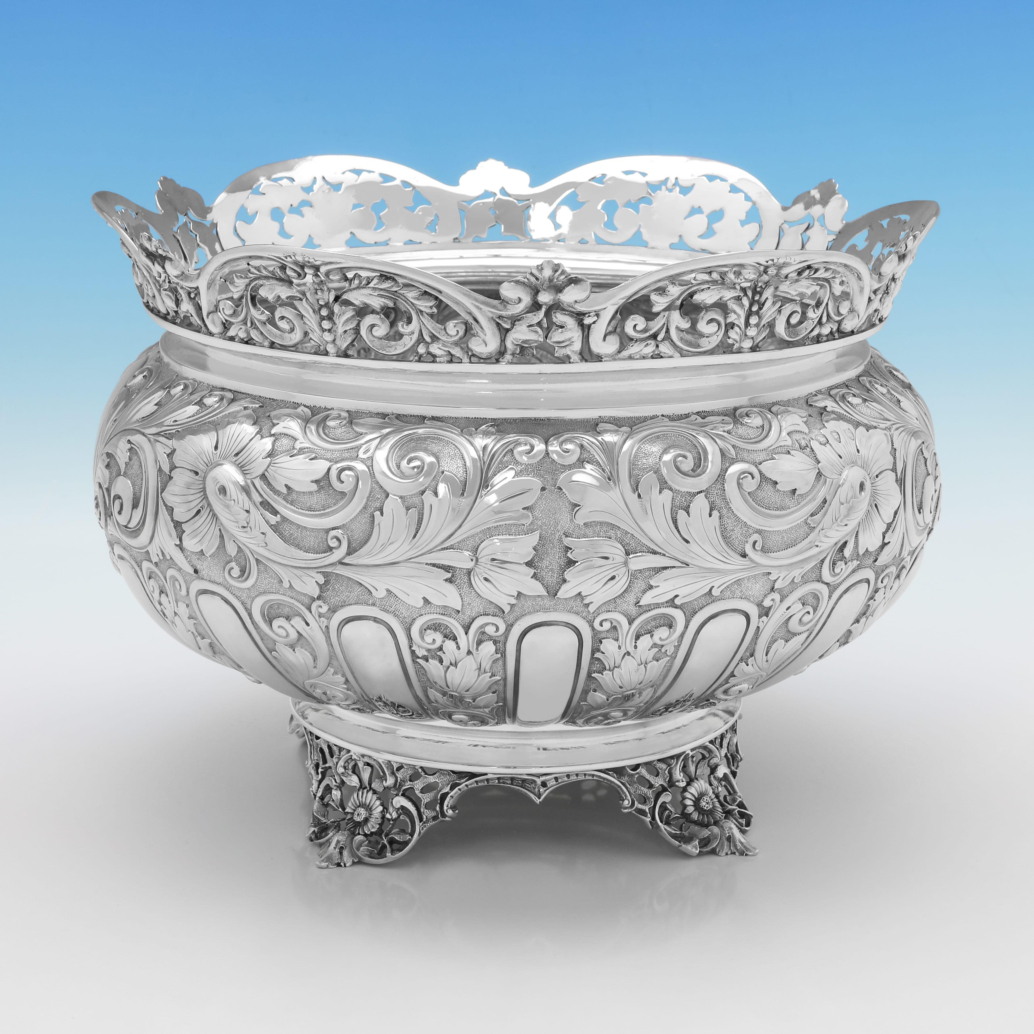Poinçonné à Londres en 1893 par Edward Hutton, ce très beau bol antique en argent sterling de l'époque victorienne est richement décoré de rinceaux ciselés, d'acanthes et de larges cannelures sur le corps, d'un rebord en argent percé et de pieds en