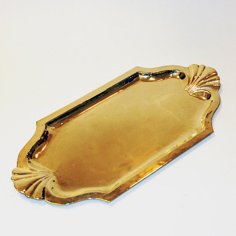 Lovely and large mid-century oval brass tray with nice edge decoration all the way around by Lars Holmström, Arvika Sweden 1930s. For decorative wall hanging, serving tray or plate at the table for fruits, cakes, vegetables etc. Lovely shell shaped