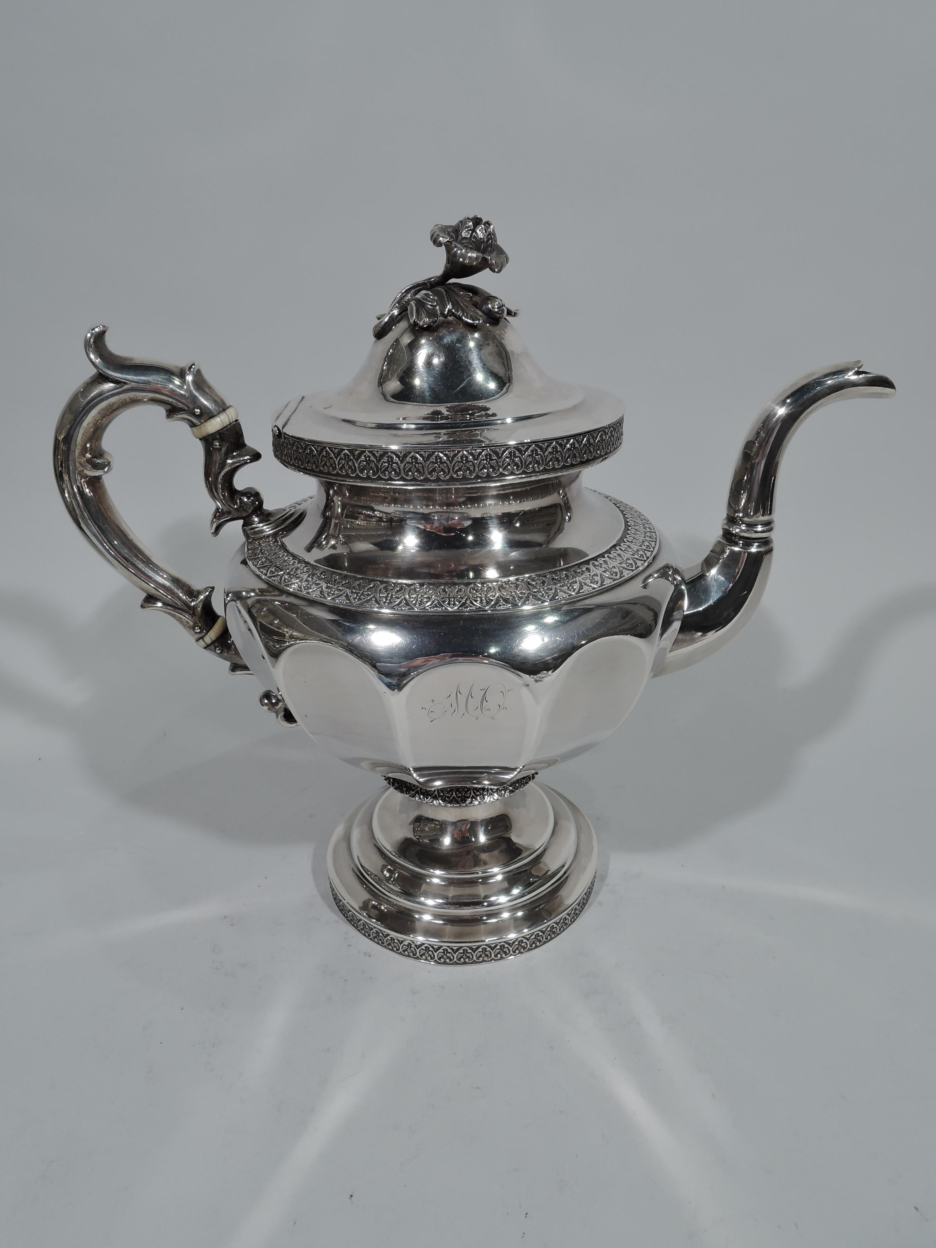 Large and pretty coin silver teapot. Made by William Forbes in New York. Fluted and ovoid body with capped and scrolled handle, faceted s-scroll spout, flange, and stepped foot. Built-in strainer. Cover domed and hinged with flower finial.