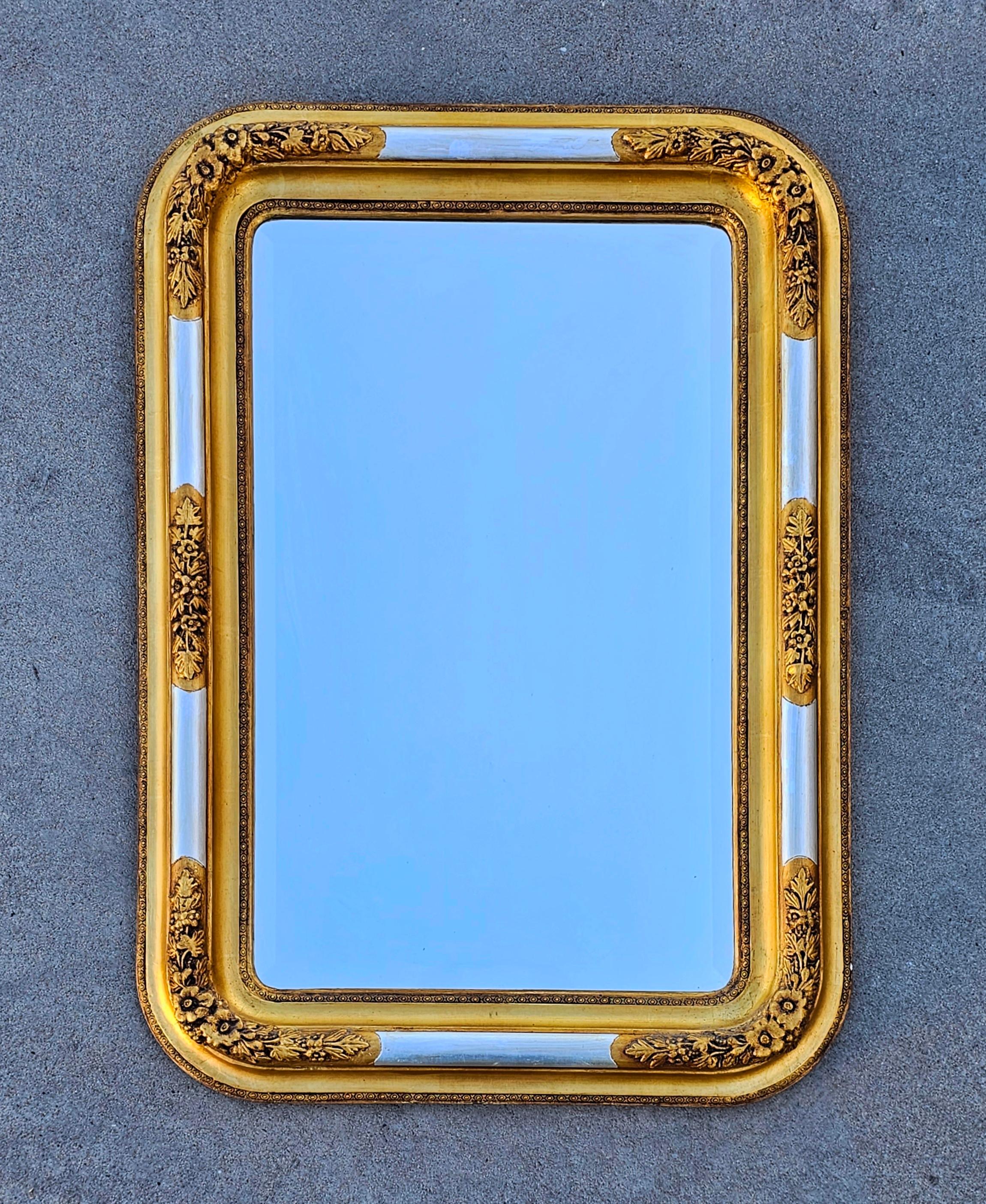 In this listing you will find a gorgeous, large and rare Biedermeier Mirror with gilt wood frame. It features a rectangular shape with rounded corners and floral decorative carvings. The frame is gilt in gold with elements done in silver. The mirror