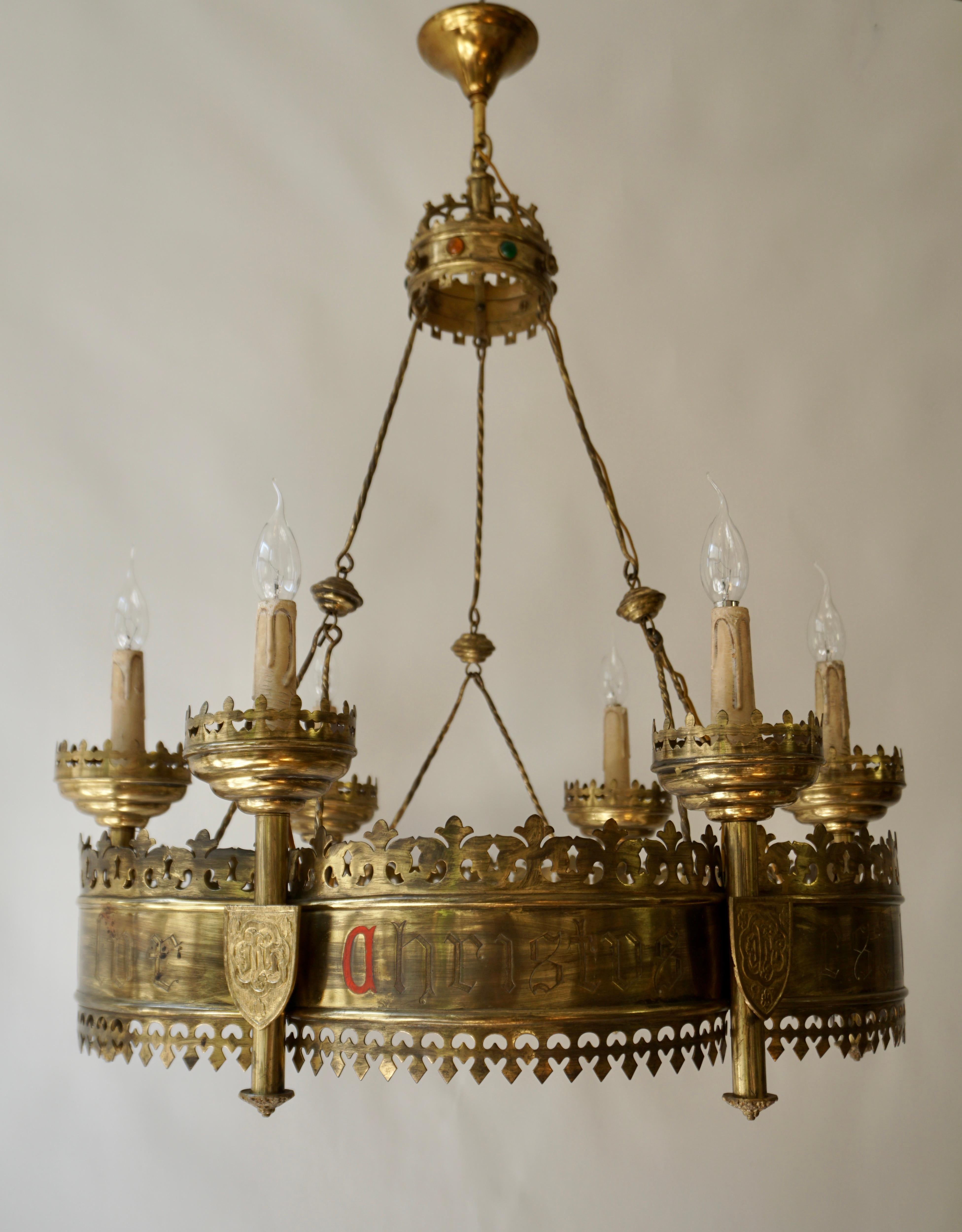 Beautiful and meaningful church relic chandelier from the late 1800s.  

This stunning and all handcrafted candle chandelier from the 1880s is designed in the shape of an advent wreath. On the outside of this Gothic chandelier are six shields with