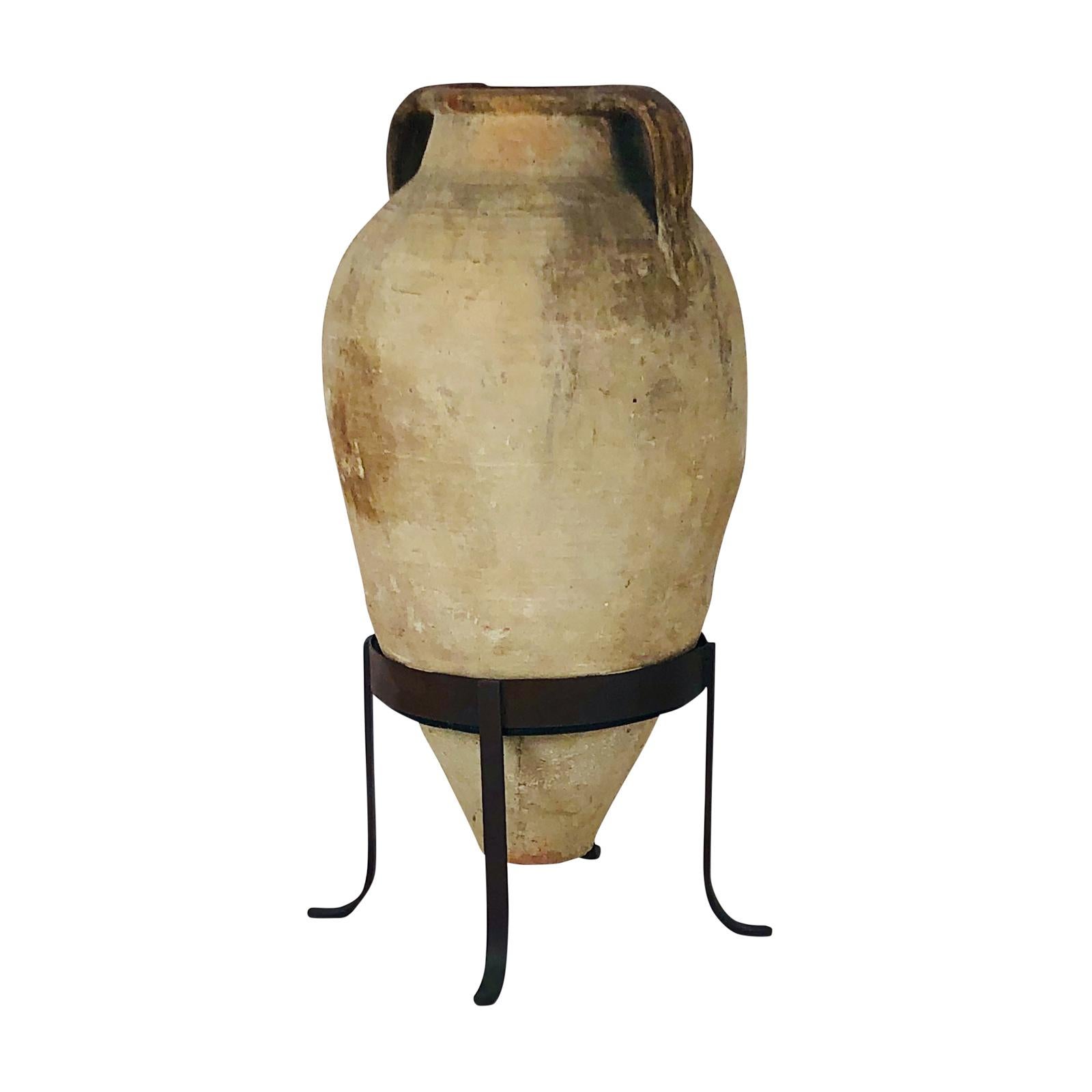 A large and tall pottery amphora from the classical period, circa 300 AD, on a later custom steel stand. These amphora were used throughout the Mediterranean area as storage jars.

 