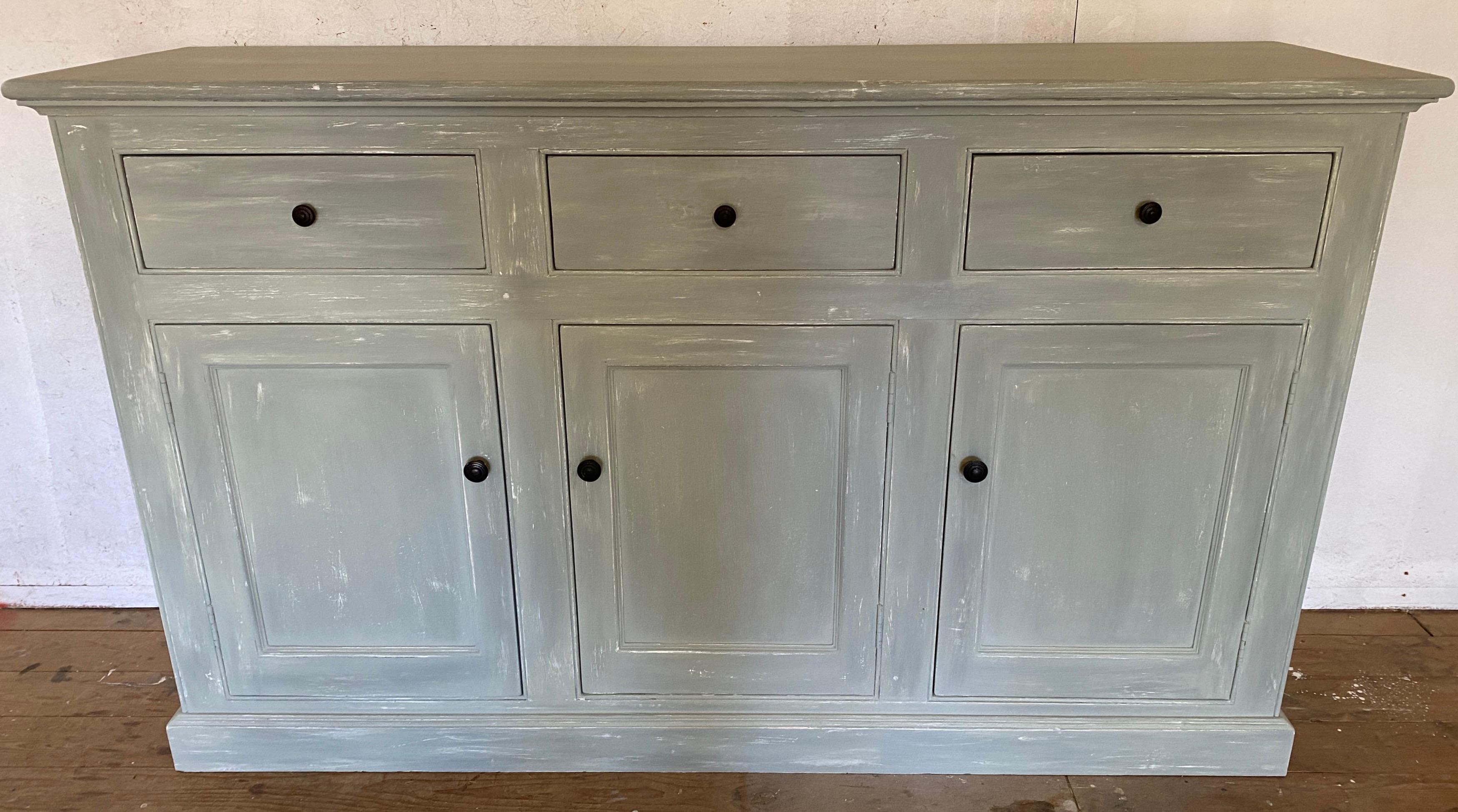 Add an American, Swedish Gustavian or French Provincial country look to your kitchen or dining room with this antique American commode or buffet server.
This handsome tall wide and deep commode kitchen chest, painted a light Swedish grey has been