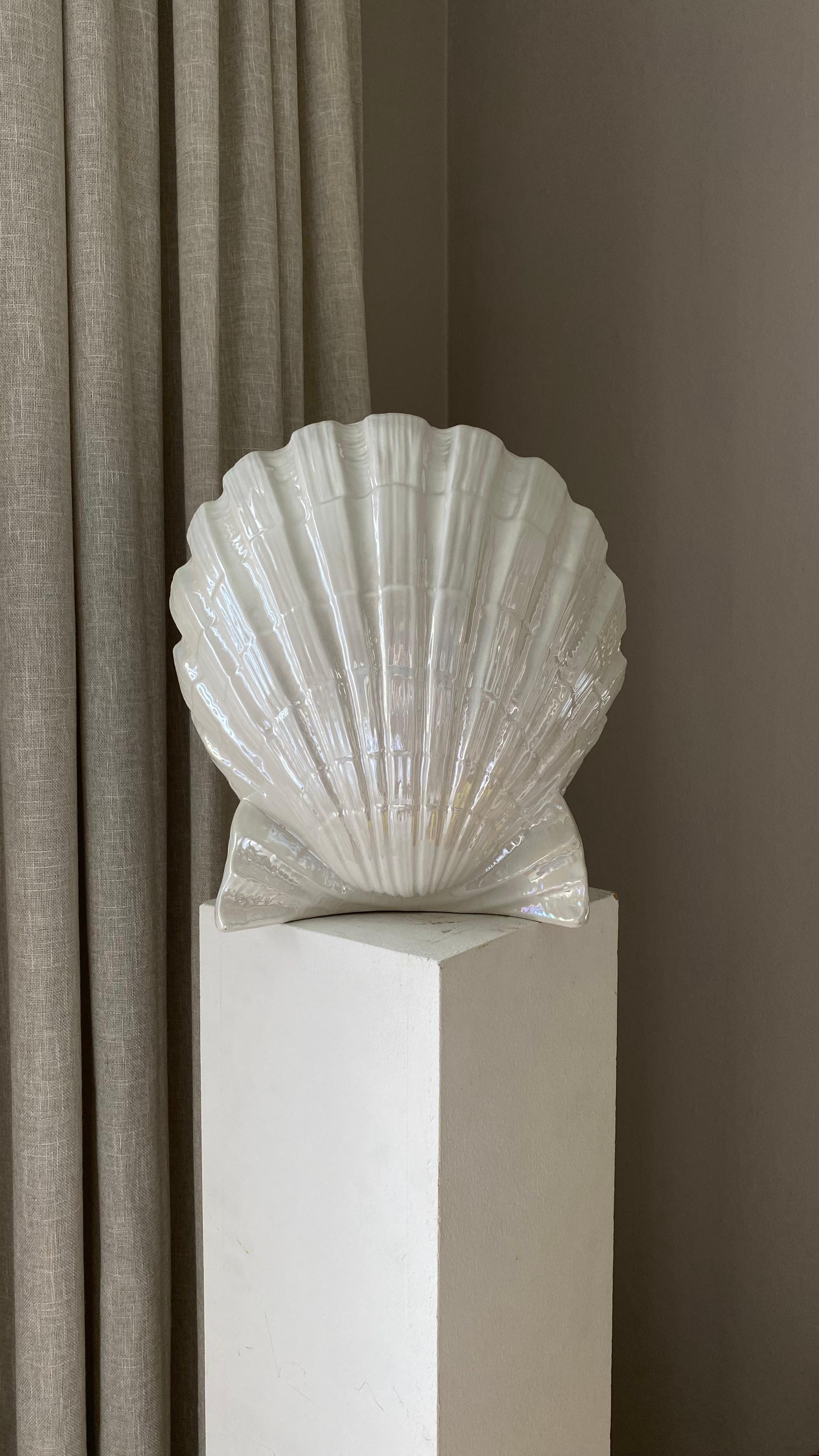 Large & unusual vintage table lamp in the shape of a shell in shimmering pearlescent white.
This elegant lamp is beautiful whether lit or lit.

Measure; Height 31, Depth 28, Width 28cm.