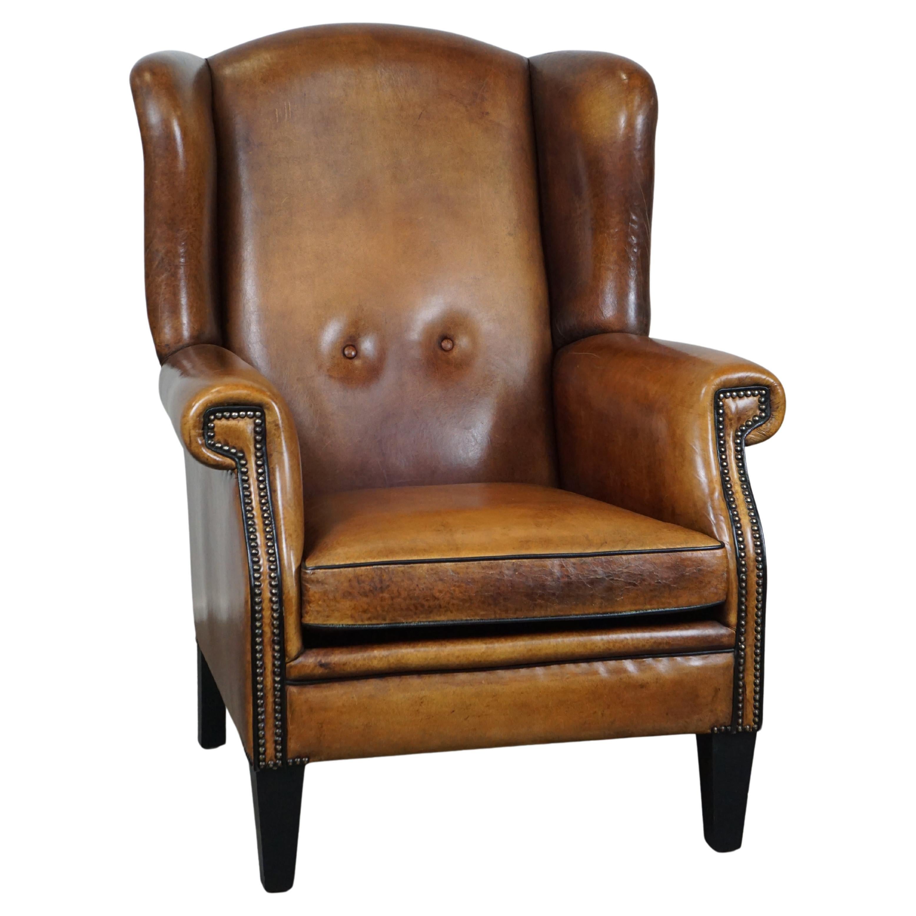Large and very comfortable wingback armchair made of sheep leather For Sale