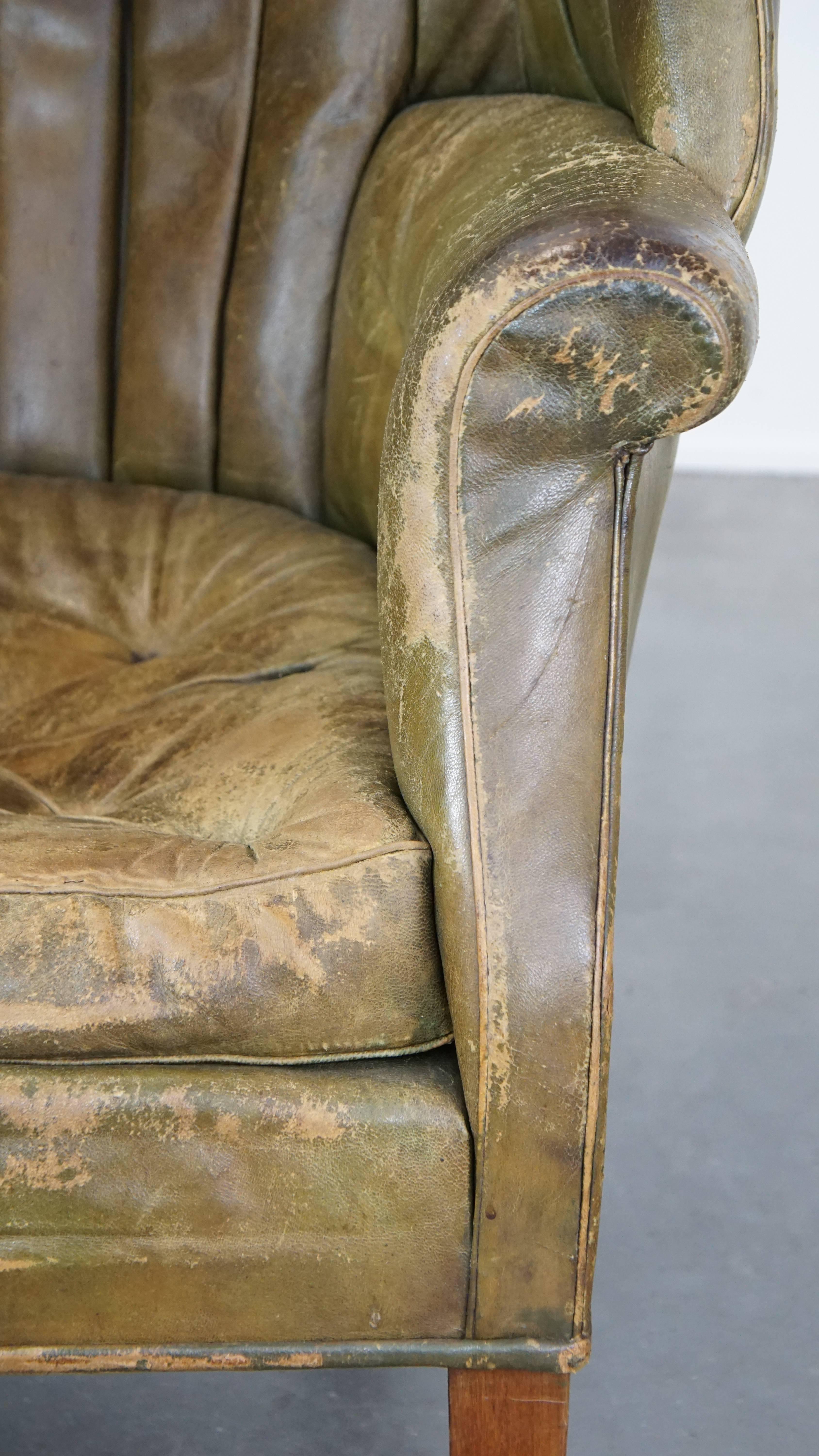 Large and well-worn green antique leather barrel-back armchair on wheels For Sale 8