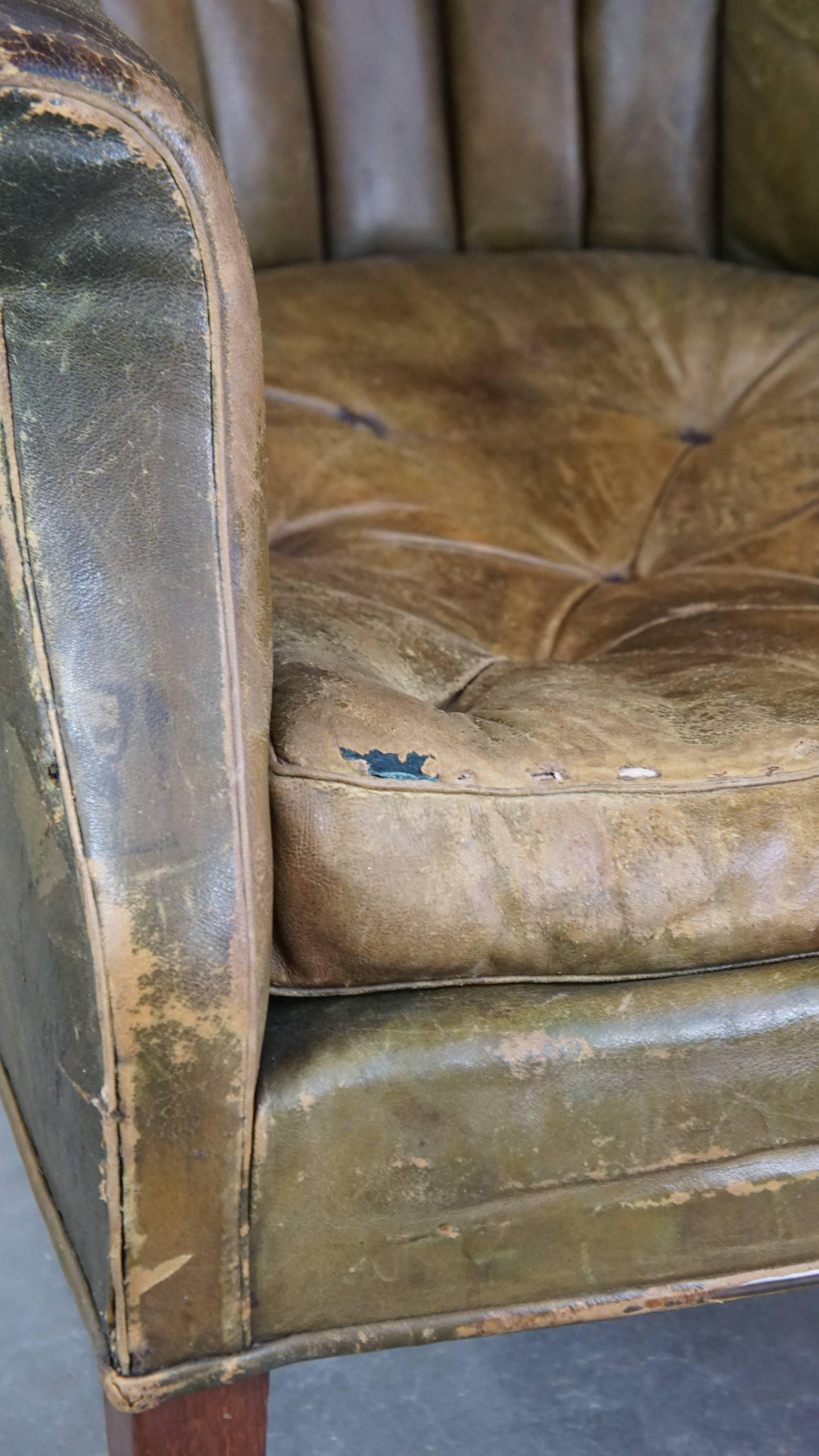 Large and well-worn green antique leather barrel-back armchair on wheels For Sale 9