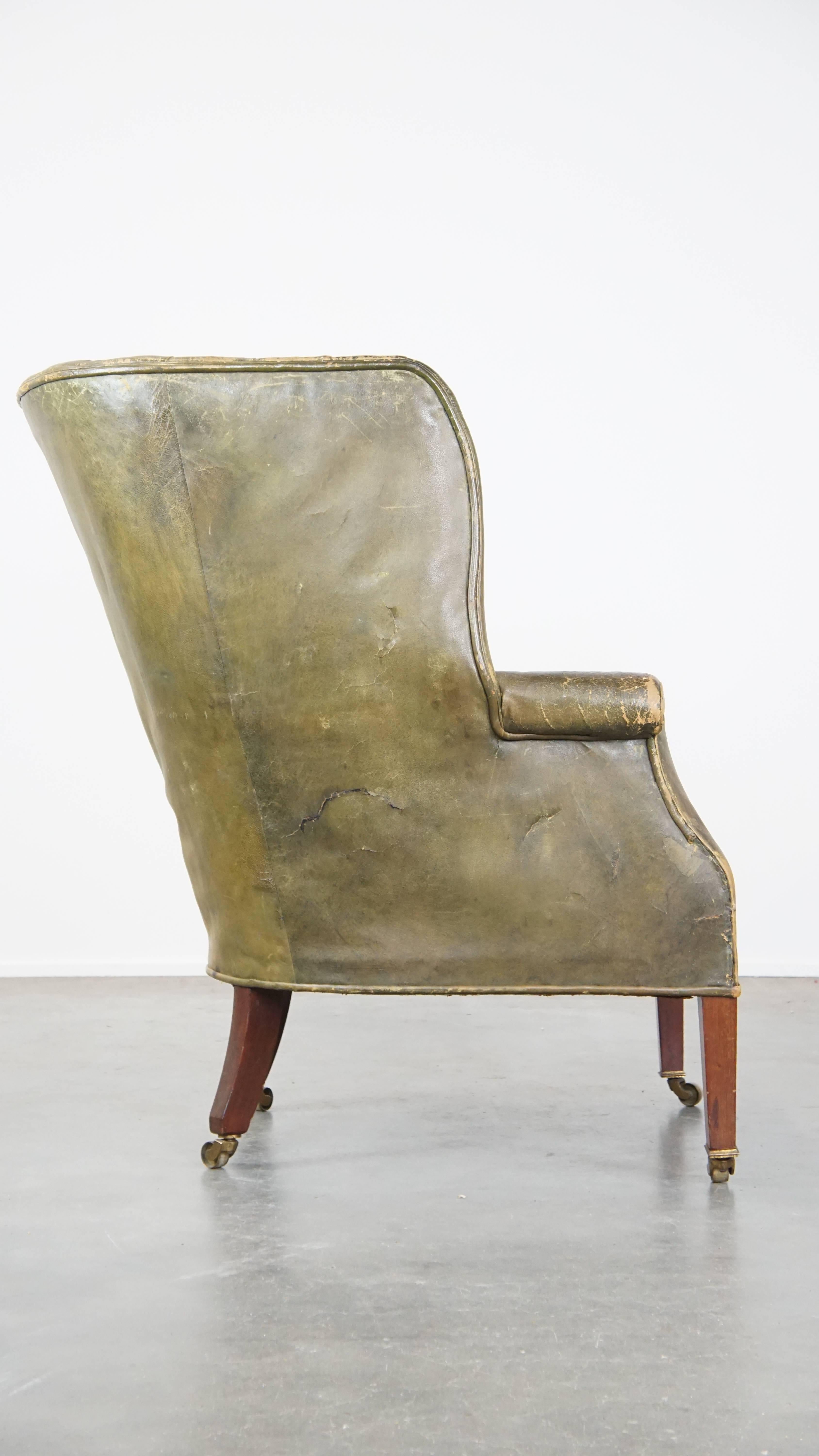 Hand-Crafted Large and well-worn green antique leather barrel-back armchair on wheels For Sale