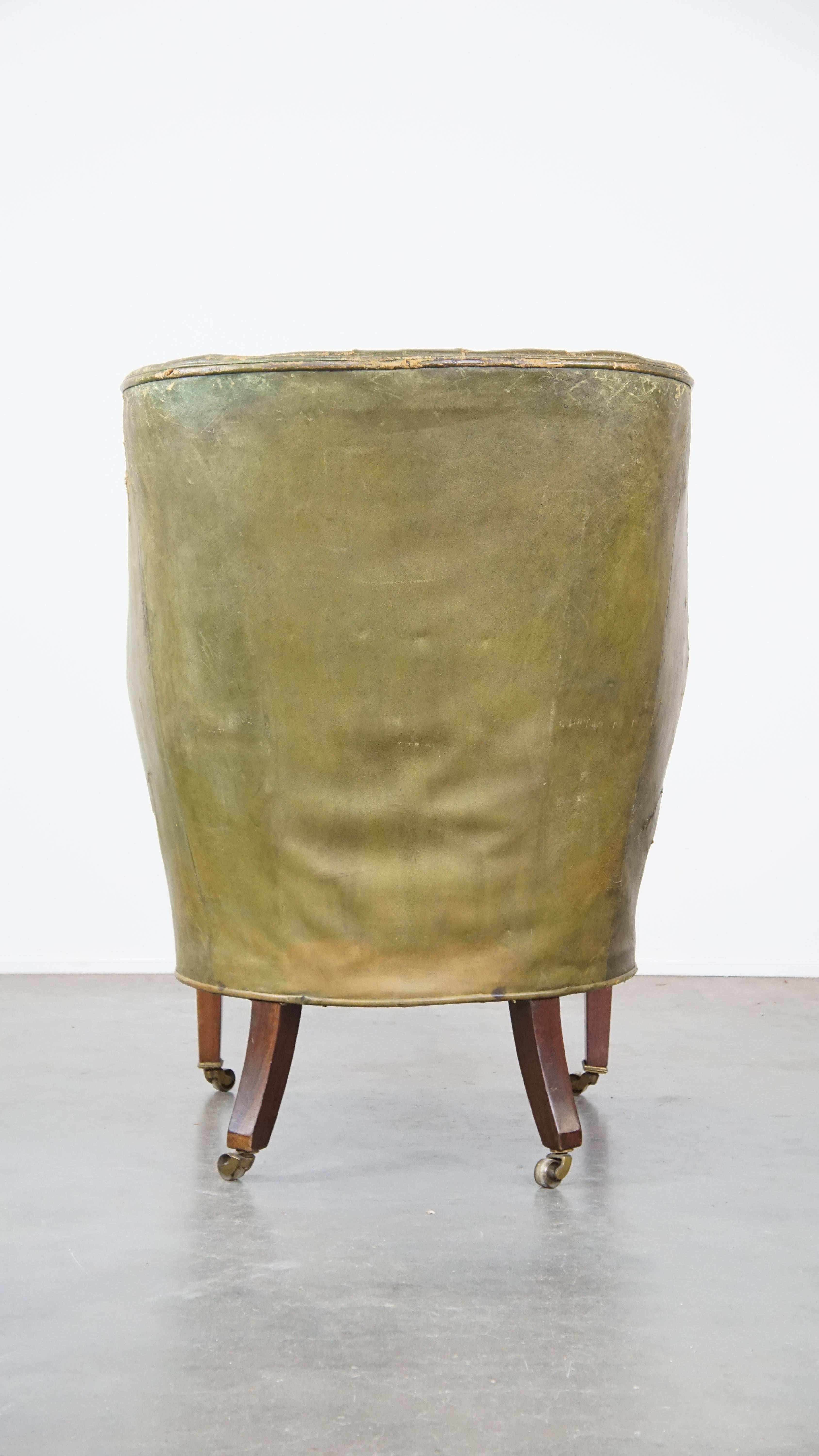 Large and well-worn green antique leather barrel-back armchair on wheels In Fair Condition For Sale In Harderwijk, NL