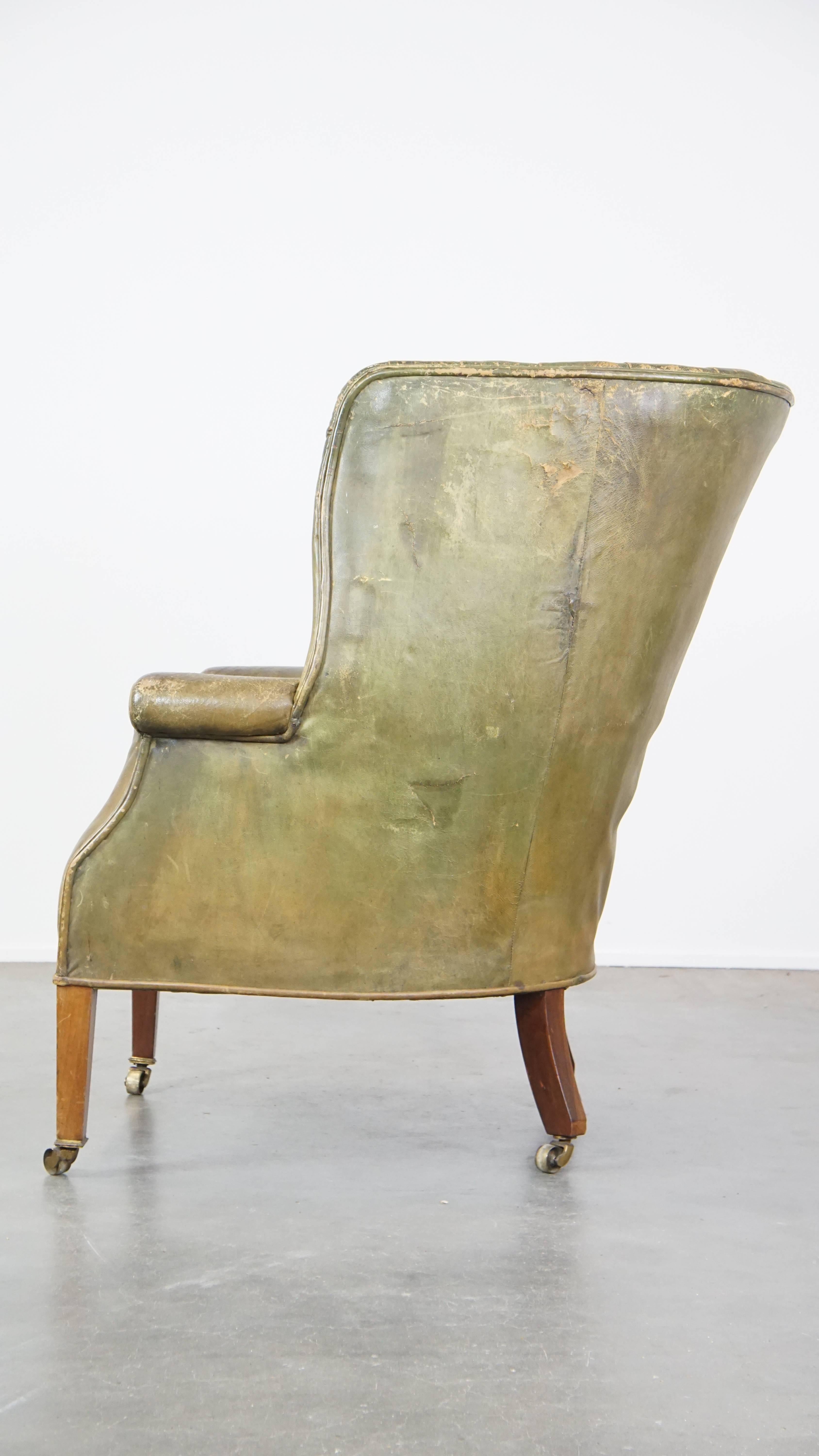 19th Century Large and well-worn green antique leather barrel-back armchair on wheels For Sale