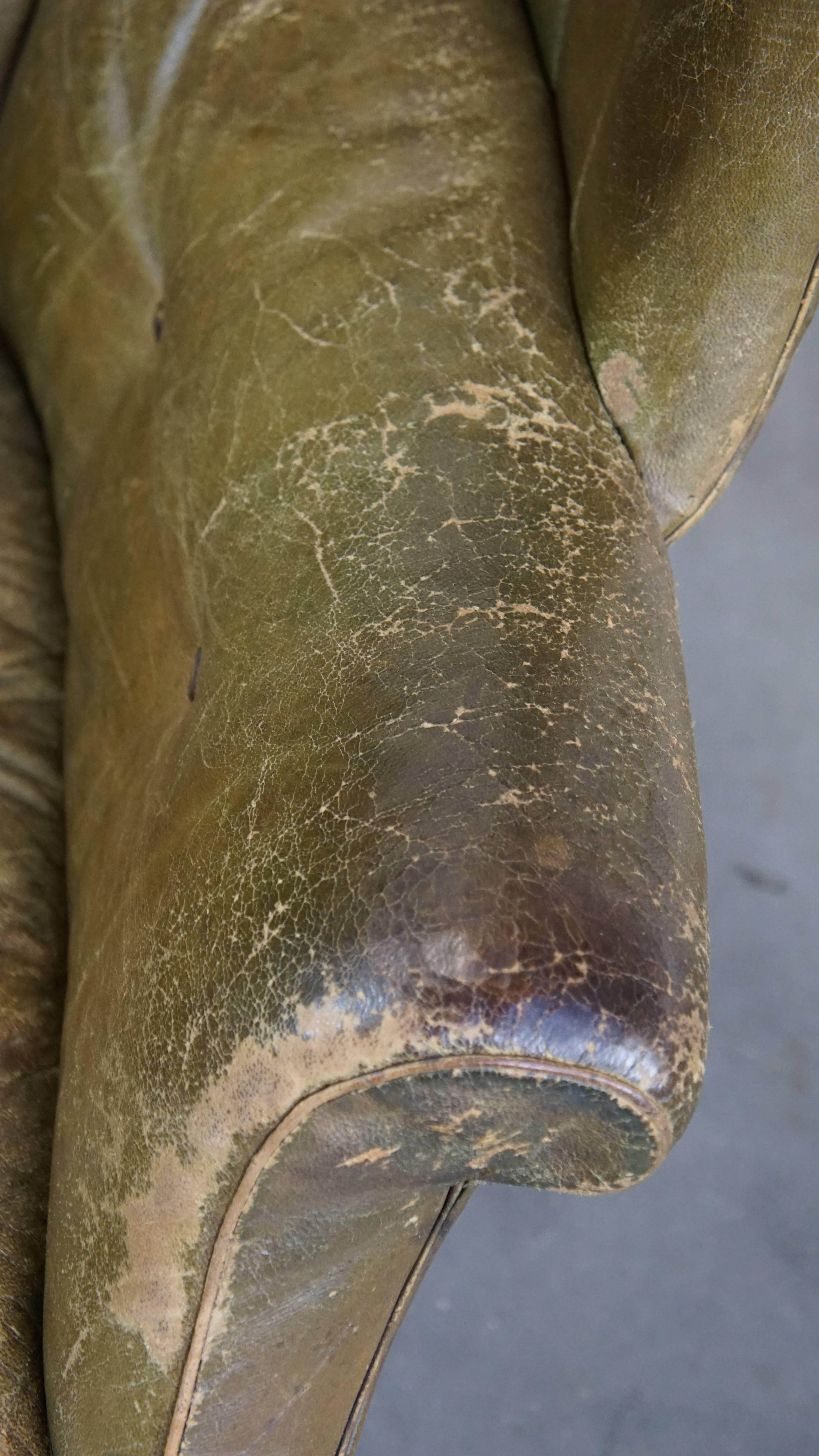 Large and well-worn green antique leather barrel-back armchair on wheels For Sale 2