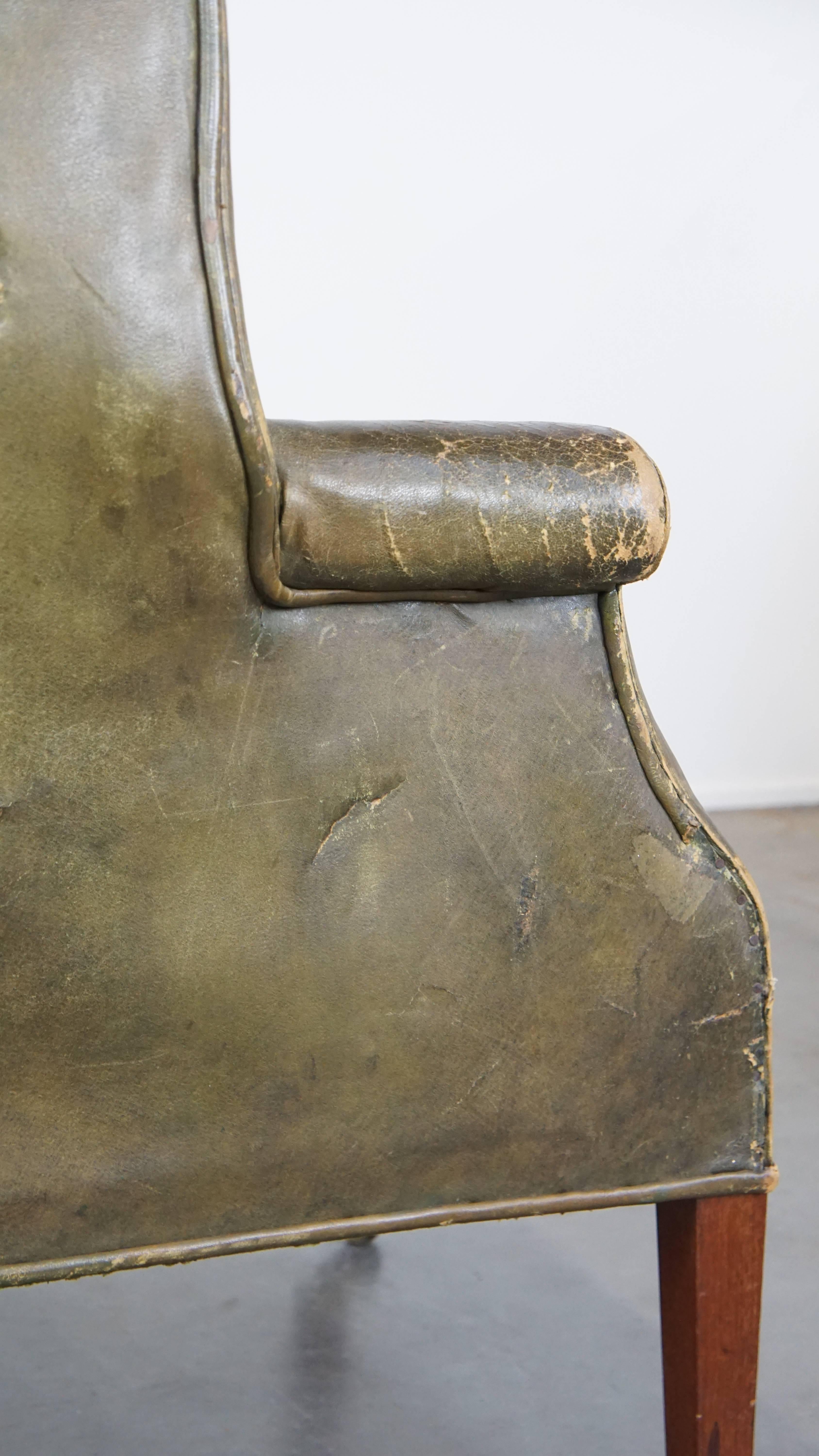 Large and well-worn green antique leather barrel-back armchair on wheels For Sale 3
