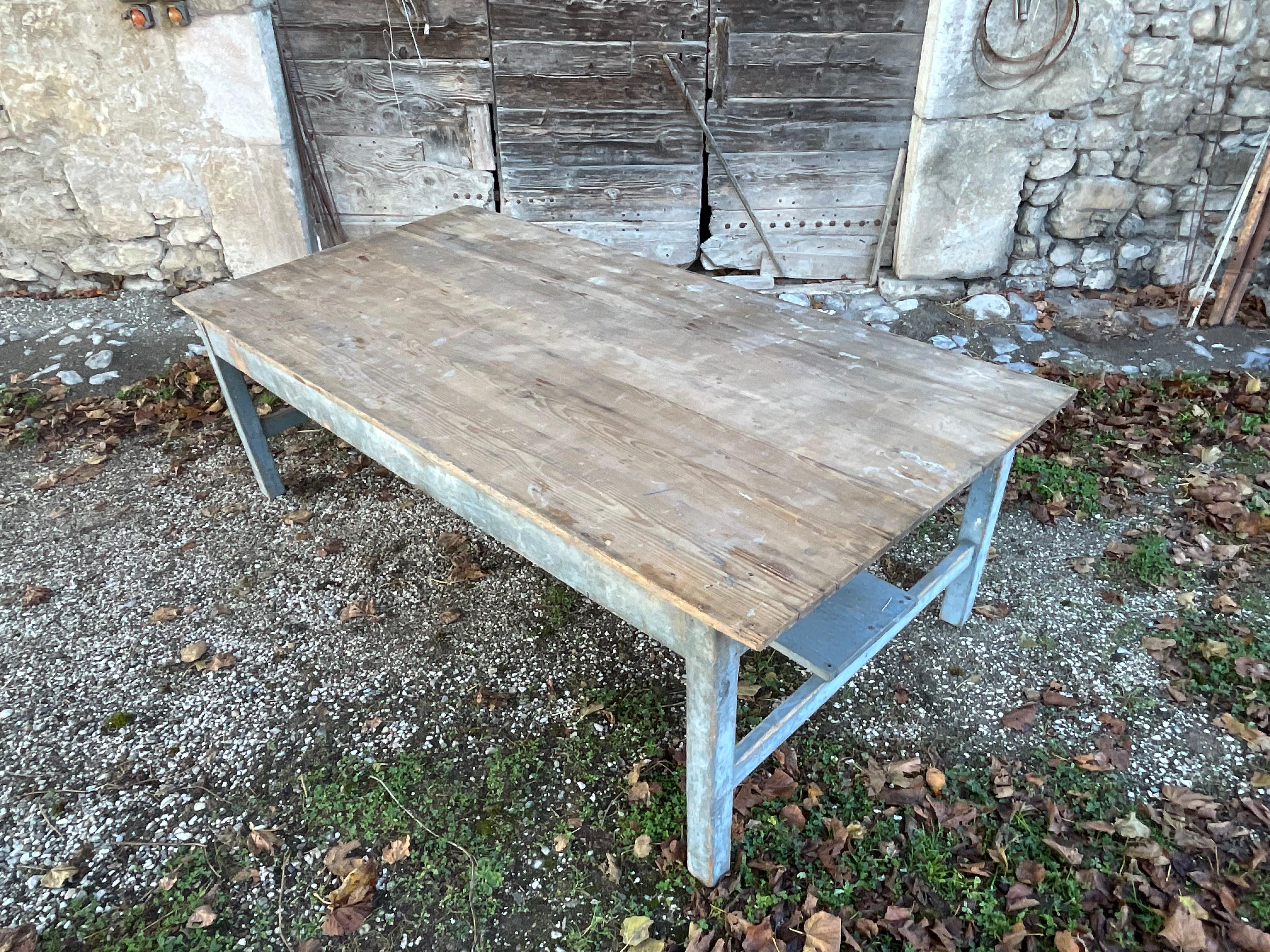 Large old farm table with its original authentic blue patina on the legs. The top is just raw and weathered by time as well. Its generous dimensions in both length and width allow it to accommodate at least 10 to 12 people. An exceptional piece that