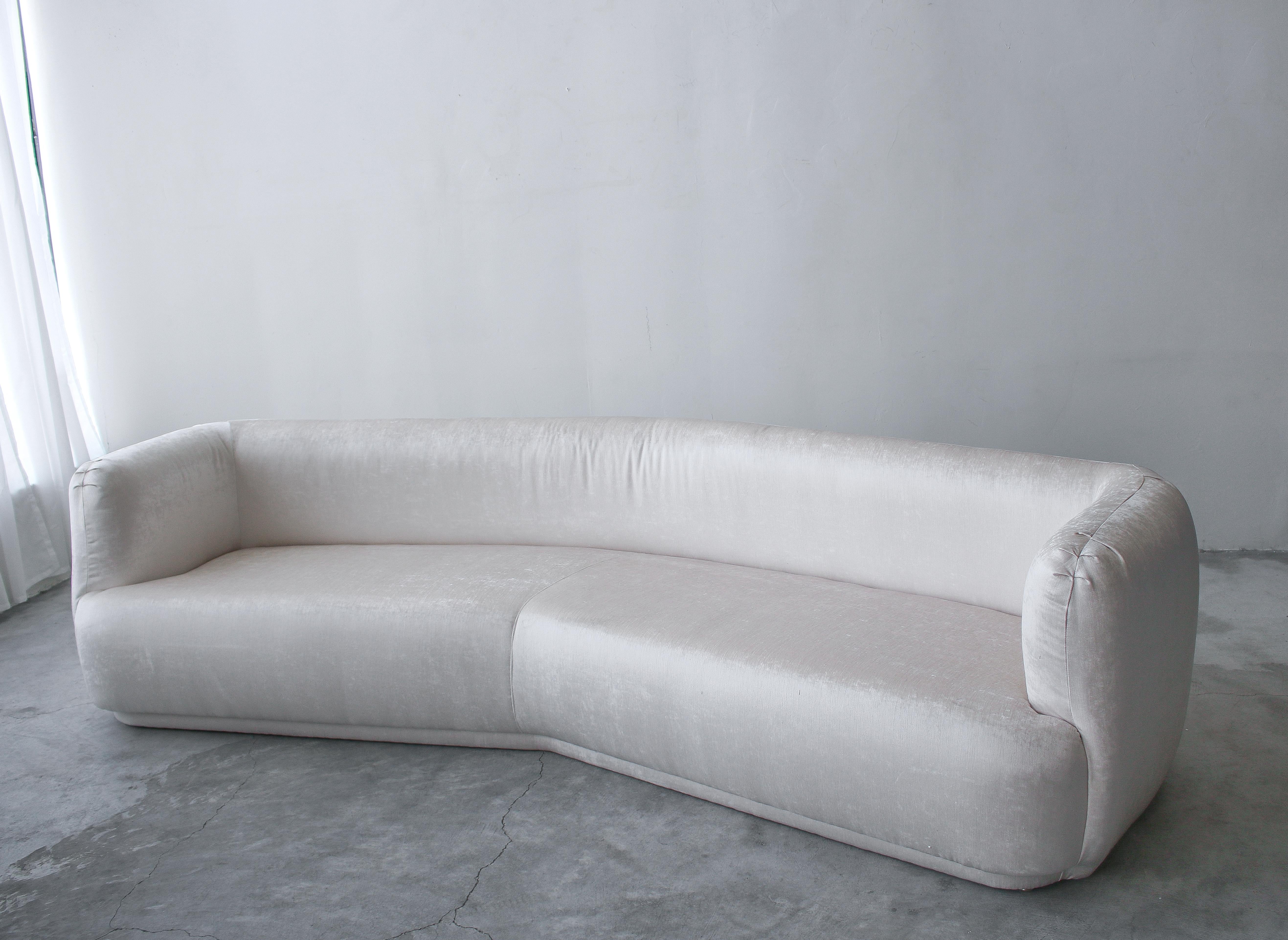 Angled sofas are rare, and to find one with these round edges is basically impossible. Stunning piece. Upholstered in a beautiful cream color, high quality velvet, this beauty is dressed to impress.

There is no damage or imperfections to be noted.