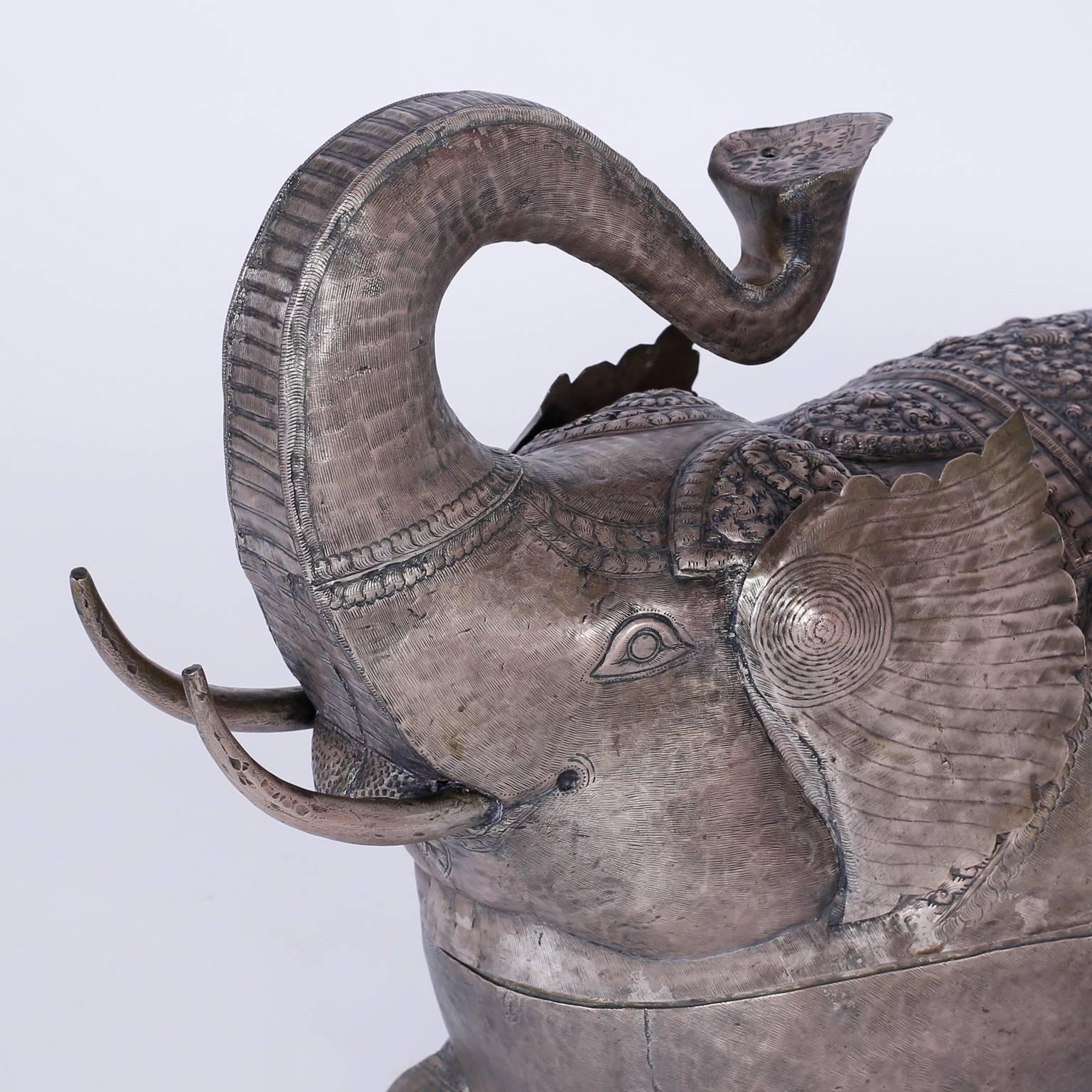 Folky silvered metal elephant handcrafted with a charming whimsical
form hammered and etched designs that unexpectedly opens as a trinket
box.