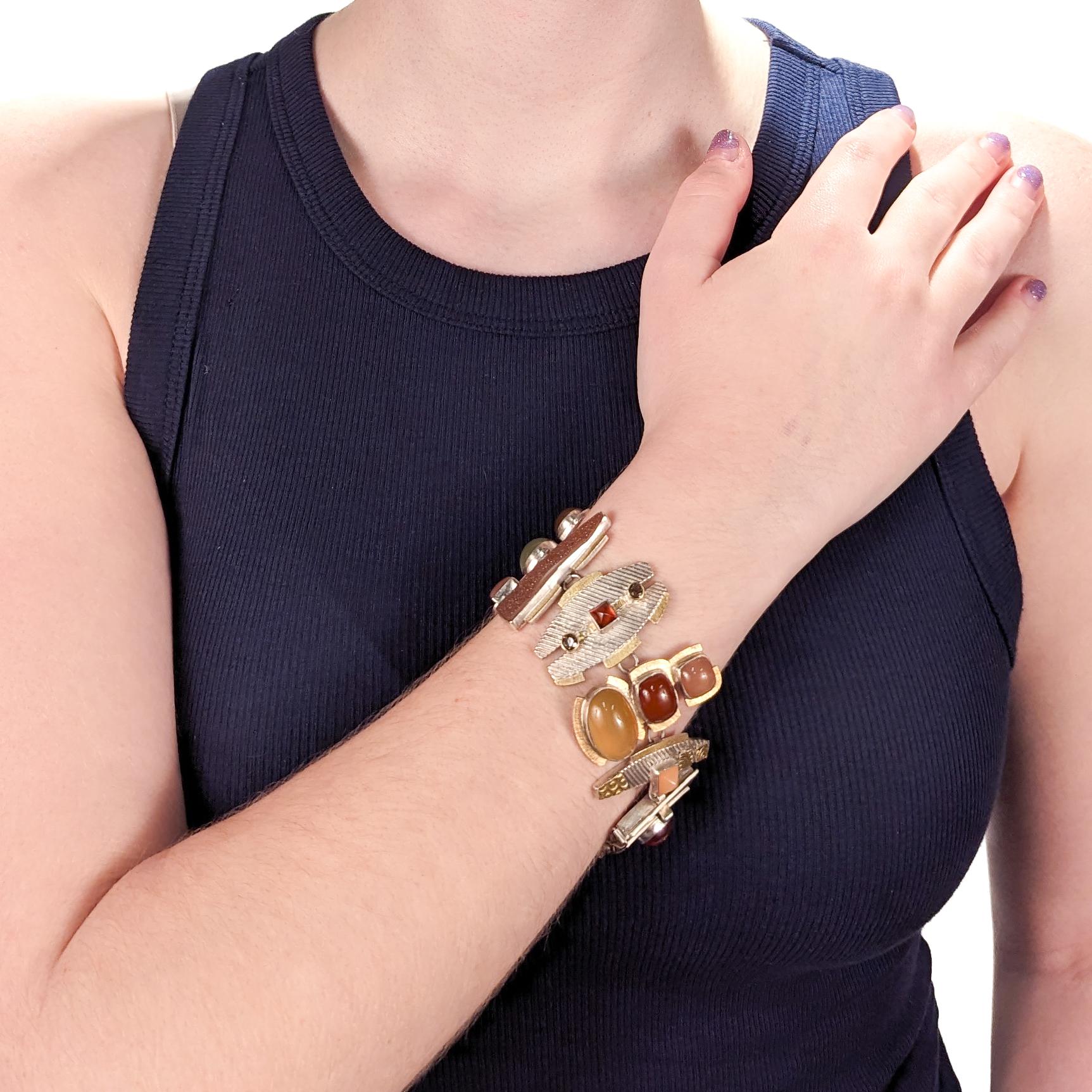 A fine artist signed, bench-made bracelet.

By Anne Besse Shepherd.

In sterling silver & 22k gold.

Bezel set with tourmaline, citrine, and quartz druzy cabochons to each link.

Signed to the reverse of the clasp.

Simply a wonderful