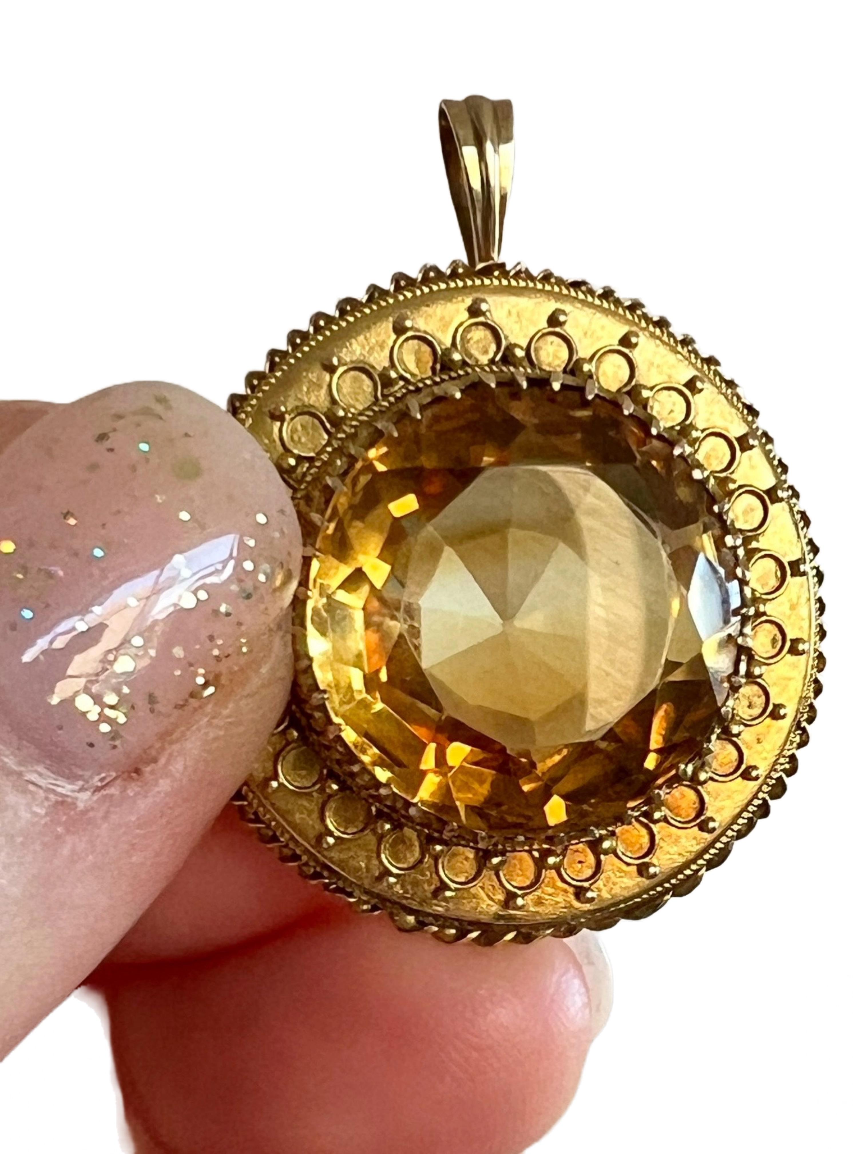 This beautiful necklace pendant is crafted from 14k yellow gold and features a large, round faceted citrine quartz gemstone in a stunning shade of medium dark orangish yellow with some lovely color banding. This pendant has a magical allure about it