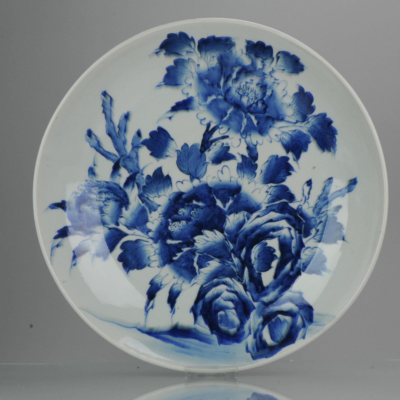 A Large and very nicely decorated Japanese Porcelain charger. Deep cobalt colors with a cool kind of blurry scene flowers, which must be Peony flowers.

The base has a nice Qianlong mark and spots where the spurs were attached for baking in the
