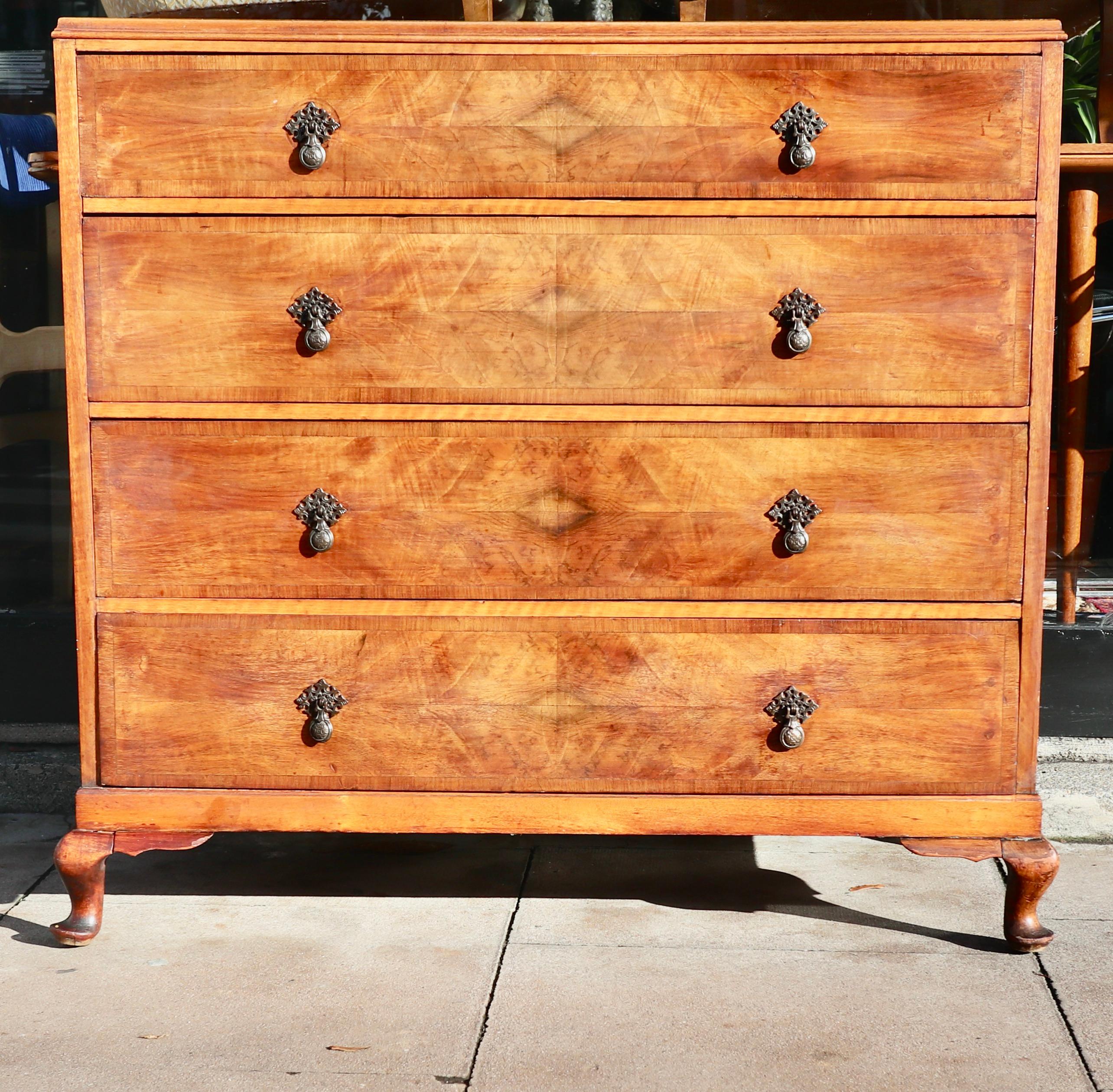 A fine and stylish large antique, English burr walnut veneered, 1920s four drawer chest of drawers with, metal handles set on carved solid mahogany cabriole legs.
This piece is in good antique condition, having been cleaned and waxed. 