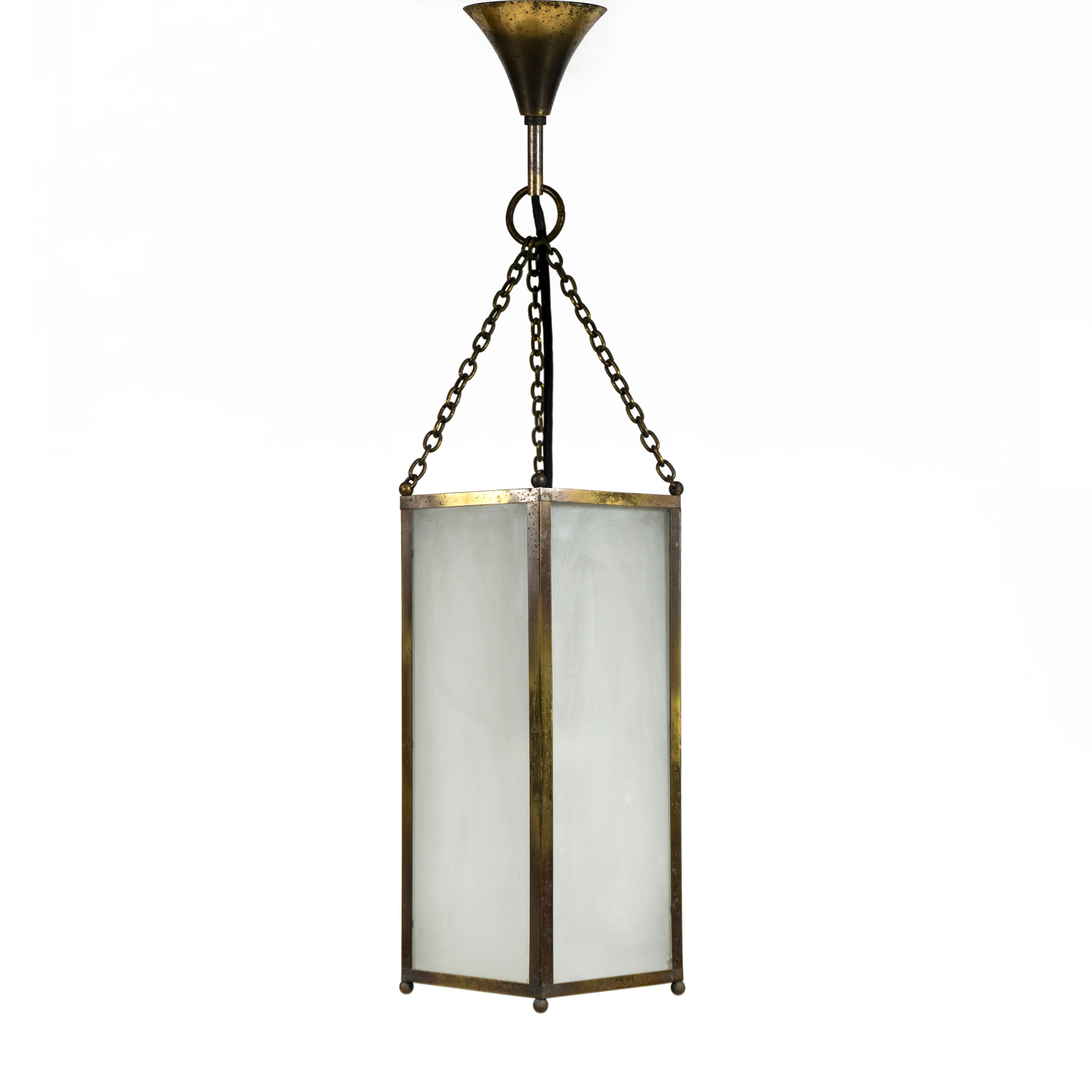Lámpara colgante antigua, grande y muy decorativa, de la década de 1940.
Este elegante farol de vestíbulo de una sola luz presenta un marco hexagonal de latón y está equipado con seis paneles laterales individuales de cristal esmerilado y un panel
