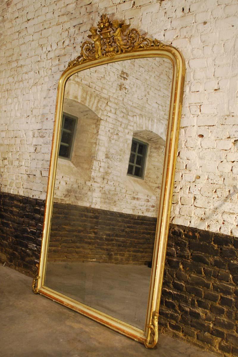 A large yet elegant Louis Philippe mirror that was made in France, circa 1870.
The mirror frame is made in solid pine and was smoothened with gesso and red earth. The mirror has a relative sleek frame compared to other mirrors from this era. The