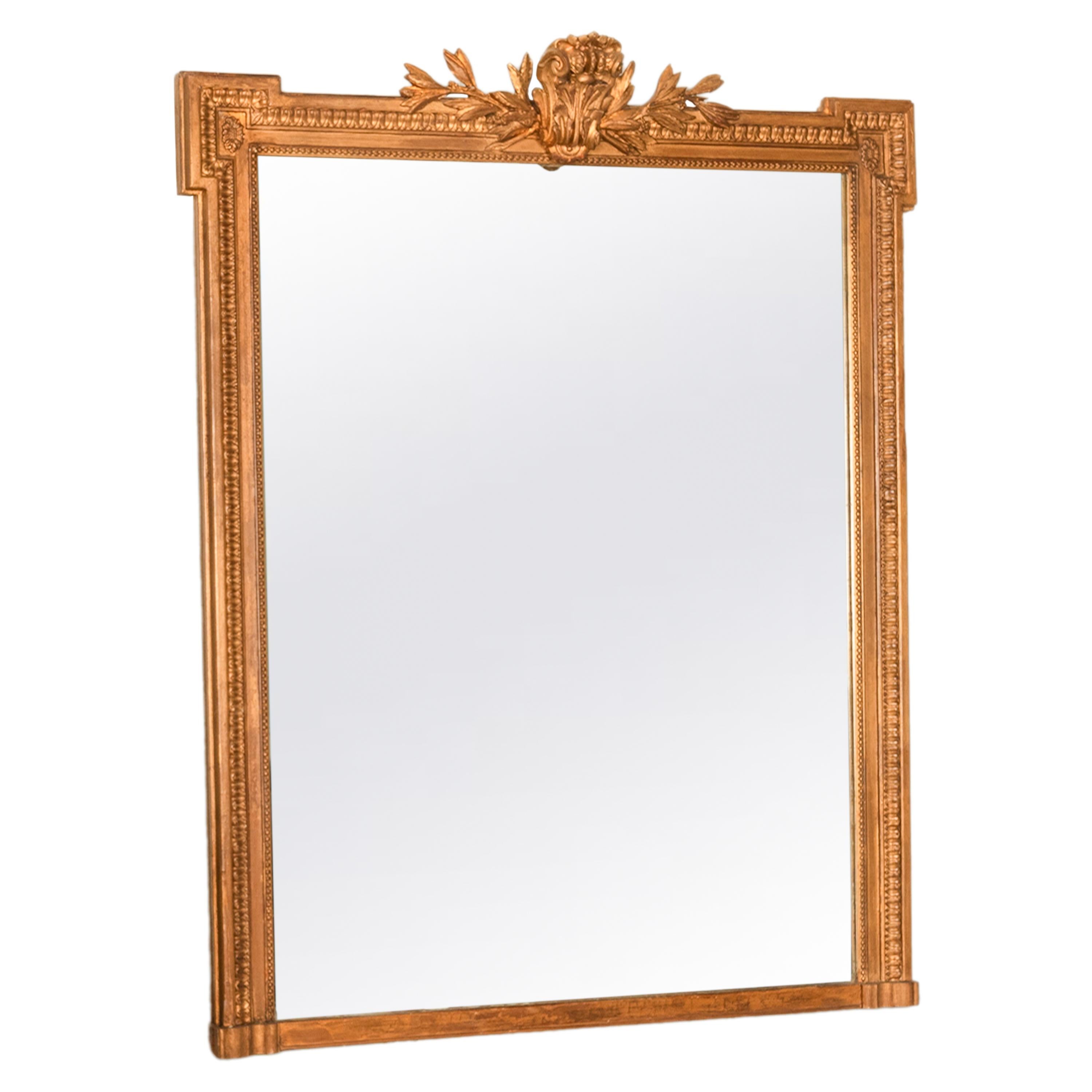 Un bon grand miroir Louis XVI en bois doré du XIXe siècle, vers 1850.
Le miroir présente une grande crête à volutes flanquée de feuillages fruités, la bordure extérieure est ornée d'une frise en forme d'œuf et de dard, les coins supérieurs sont