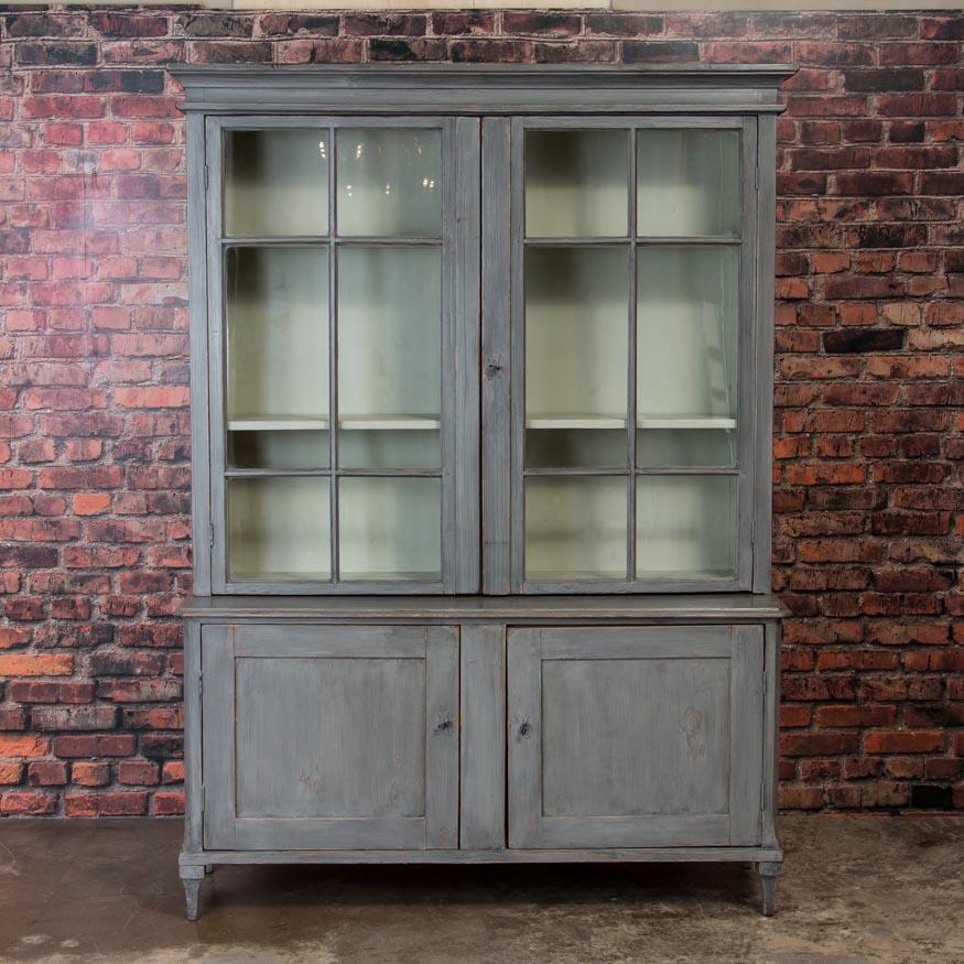 The gray paint on this striking large bookcase or display wall unit, has been lightly distressed and has a warm, inviting patina. Adding to the strong country appeal, the entire piece has a satin wax finish, is very sturdy and all components