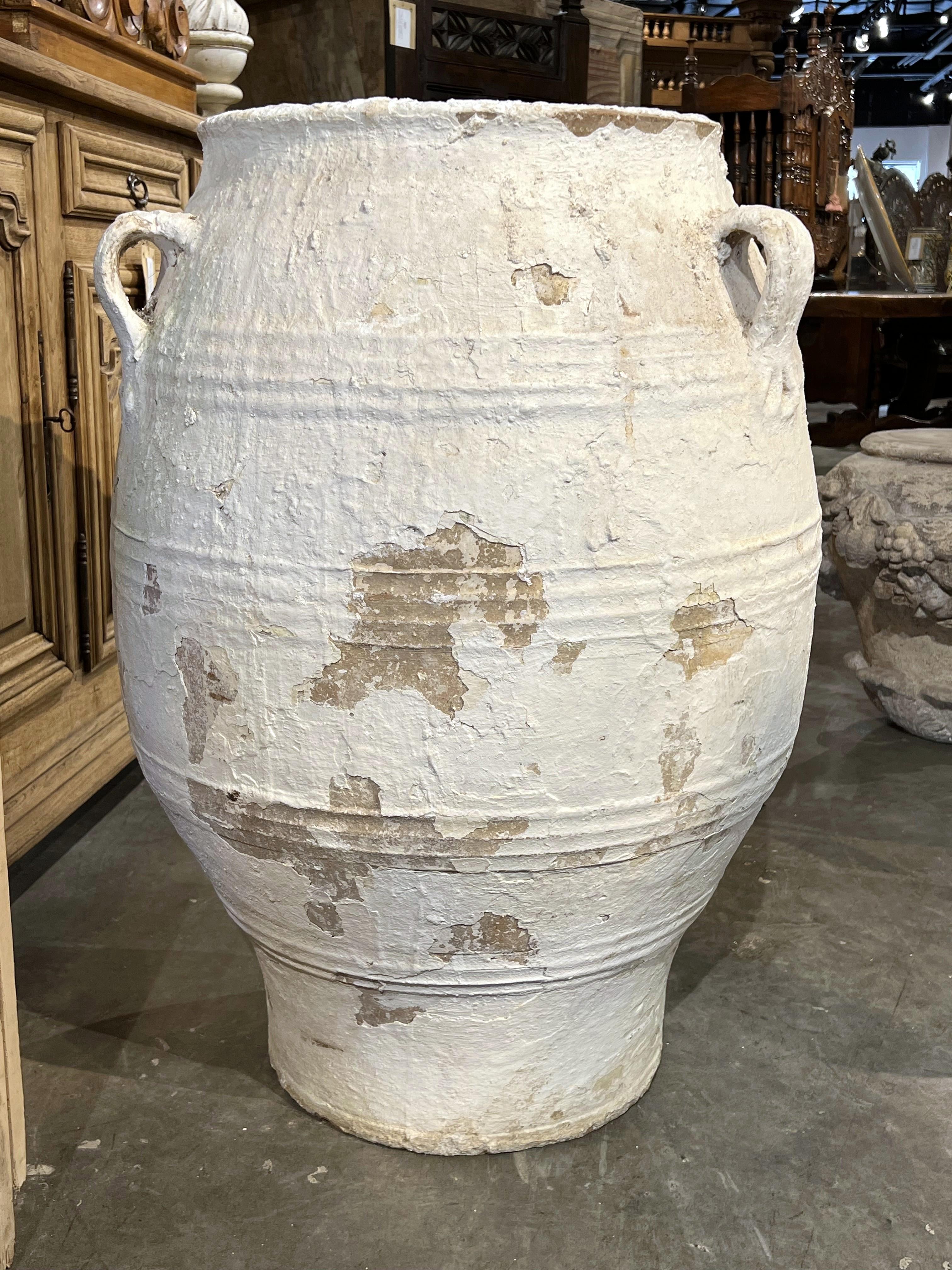 Más información próximamente...

Esta gran olla se habría utilizado hacia 1875 para almacenar aceite de oliva o vino en Grecia.  La singular vasija, pintada a mano en blanco mediante una técnica de empaste, tiene cuatro grupos de crestas