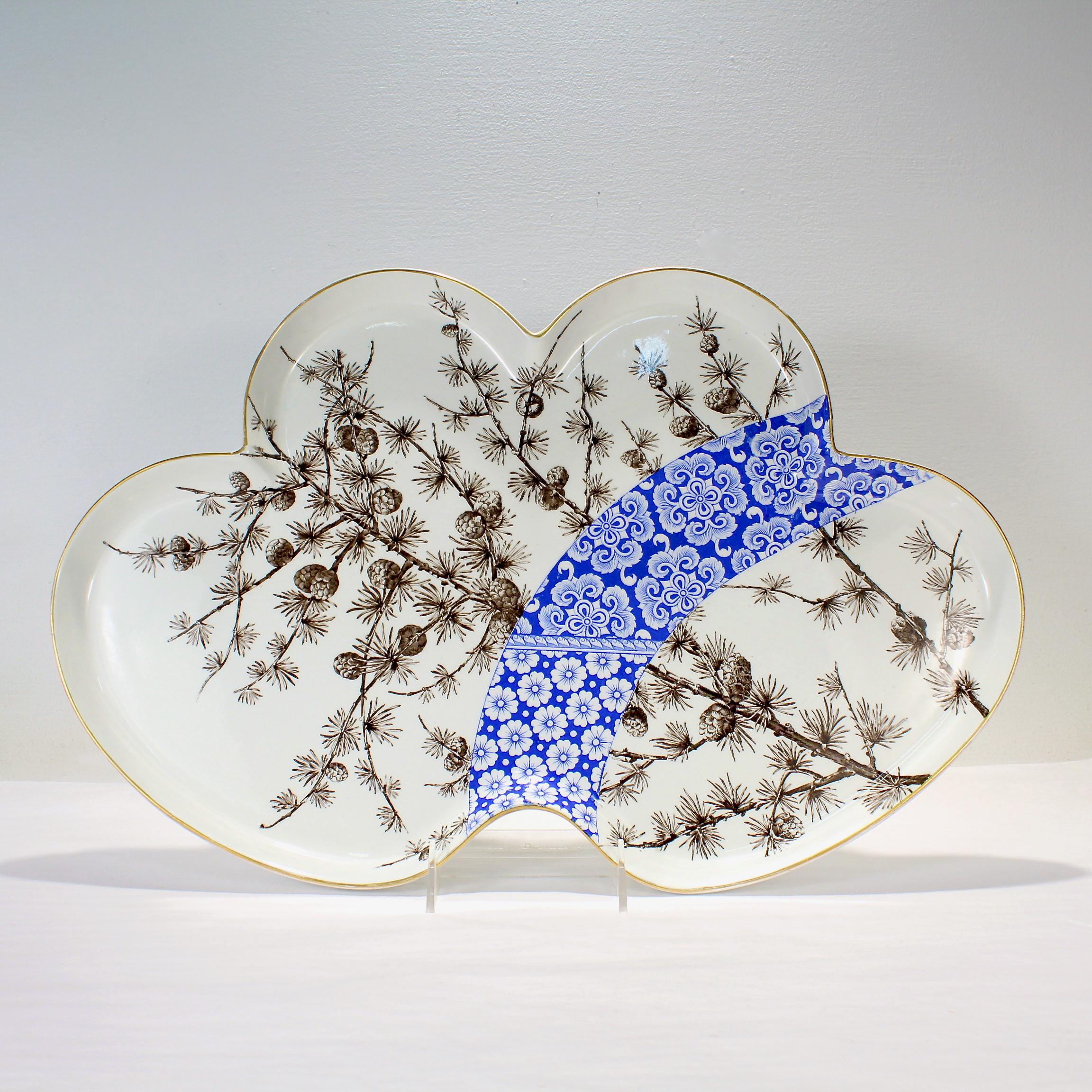 A fine antique porcelain tray.

By Royal Worcester.

Transfer decorated throughout with black and white pinecones & pine needles which are bisected by a striking band of blue & white floral motifs. 

The tray's rim is gilded.

Simply a