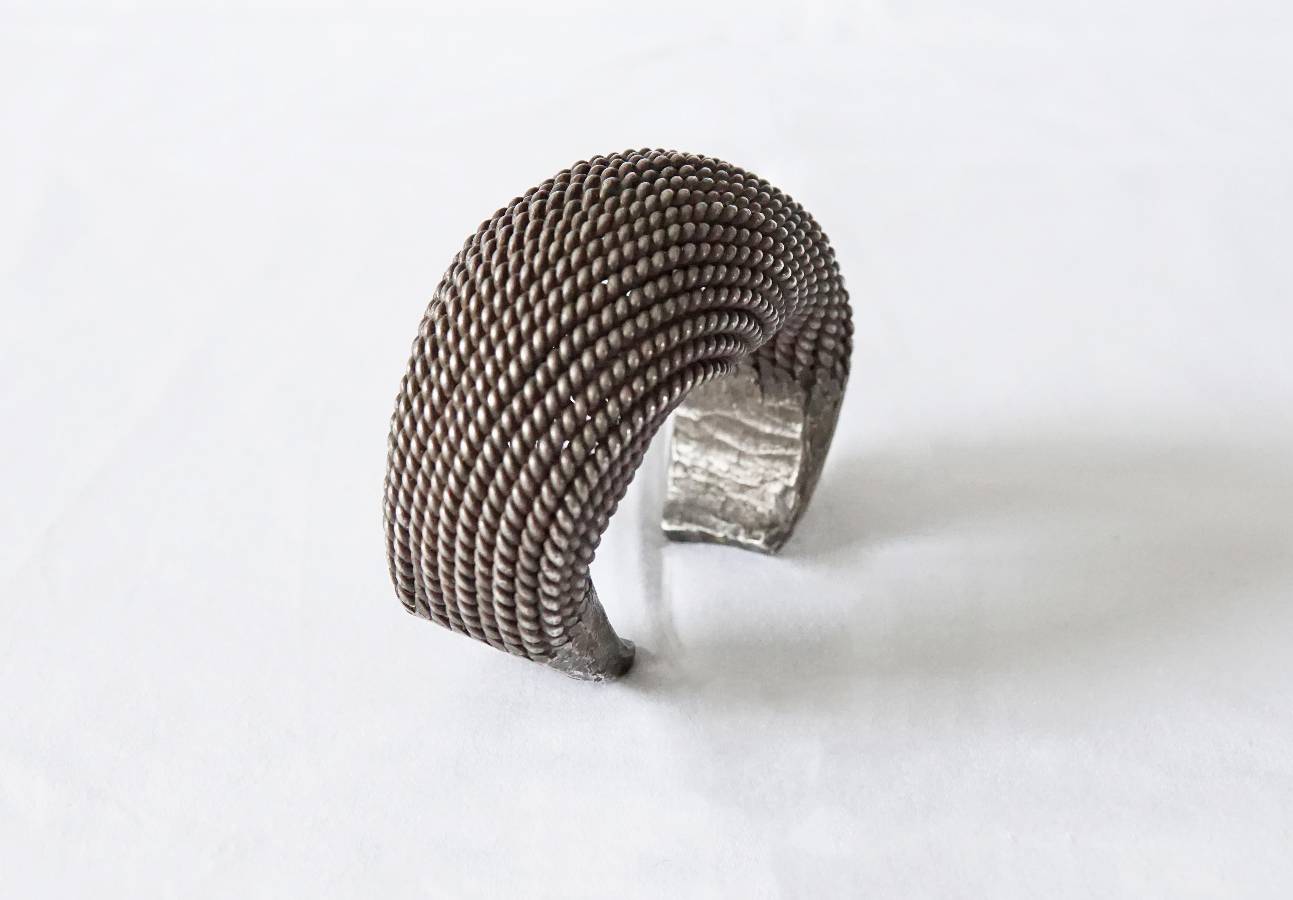 A large Akha Tribe woven silver bracelet with spiral design. This Tribal bracelet encompasses tradition Hill tribe silversmithing techniques with each silver strand crafted and woven by hand. This bracelet is slightly adjustable to fit different