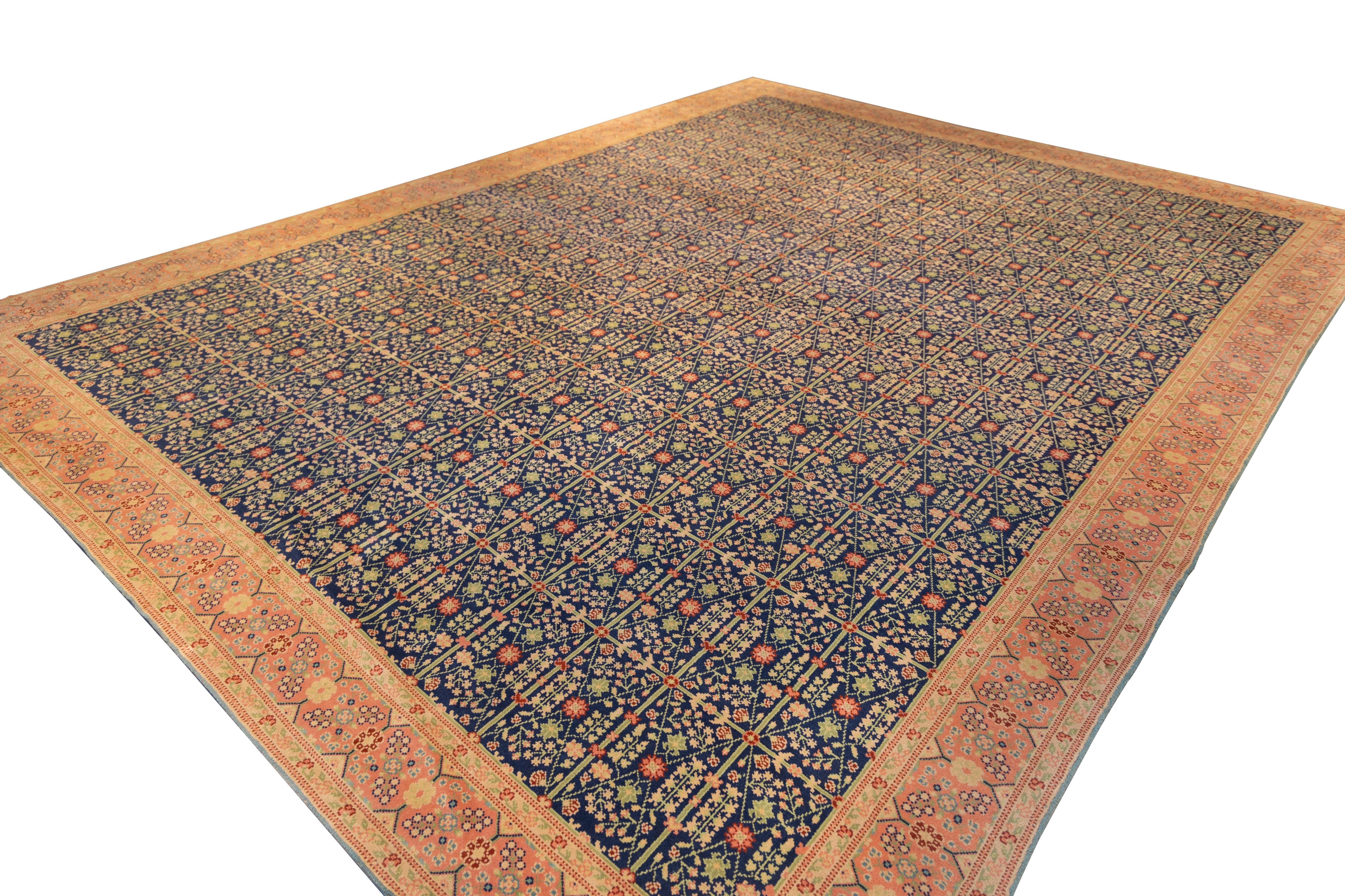 Elegant 1920s Spanish carpet showcases a striking allover latticework pattern rendered in deep indigo, saffron, and coral tones. Each compartment is meticulously filled with stylized floral motifs and rosettes, arranged in rhythmic precision that