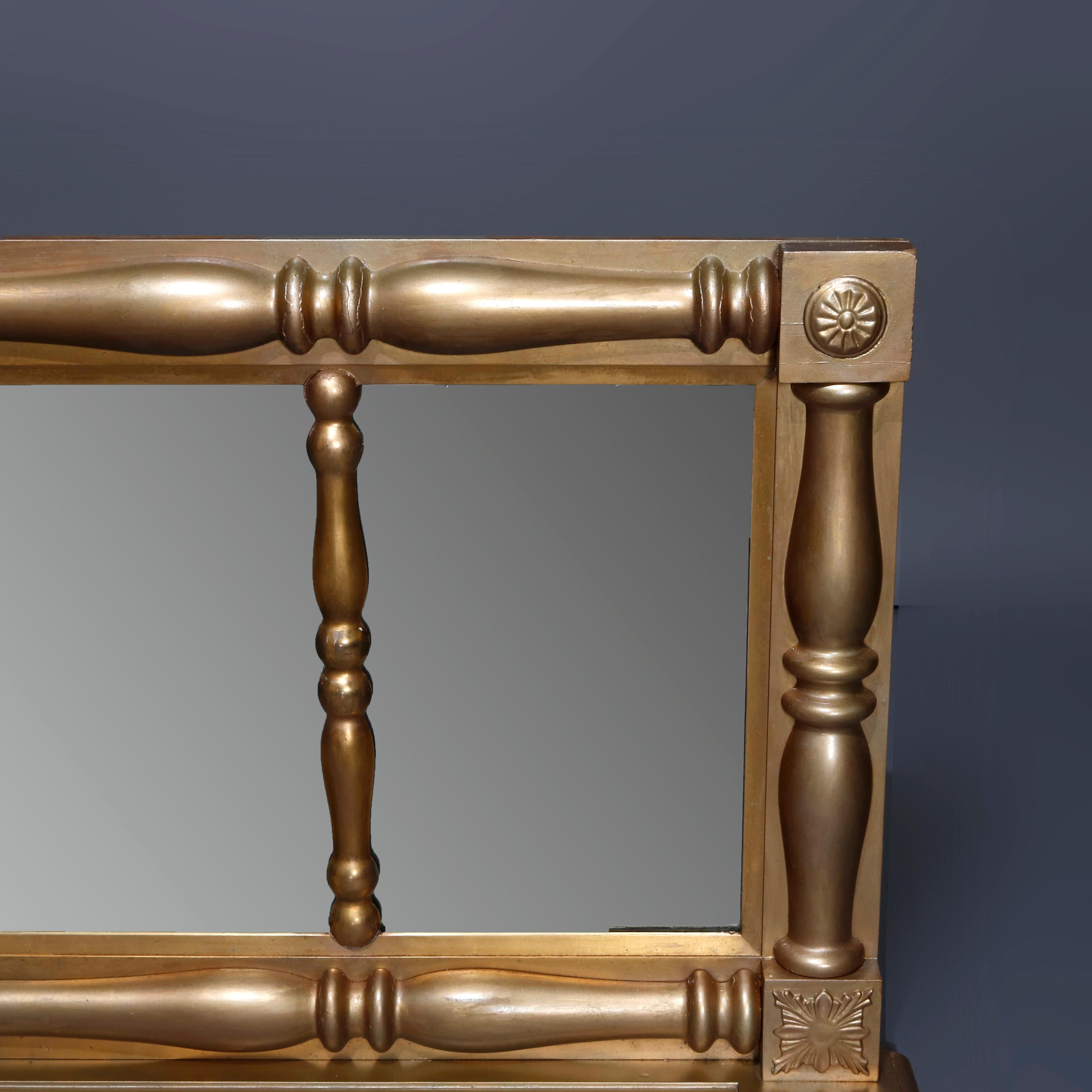 A large antique American Empire over mantel mirror offers triptych form with column-form giltwood frame with rosette corners, circa 1840.


Measures: 26.75