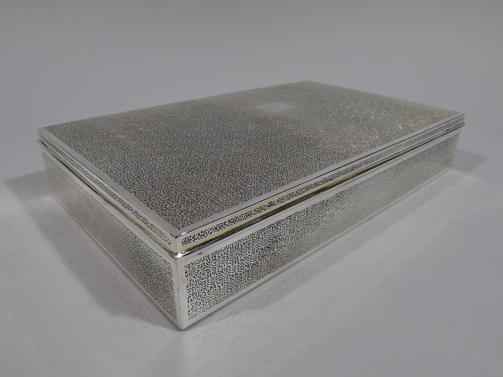 Large sterling silver box. Made by Tiffany & Co. in New York, circa 1920. Rectangular with straight sides. Cover gently curved and hinged with wraparound molded rim. Fine interlocking Moresque ornament acid-etched all-over sides and cover between