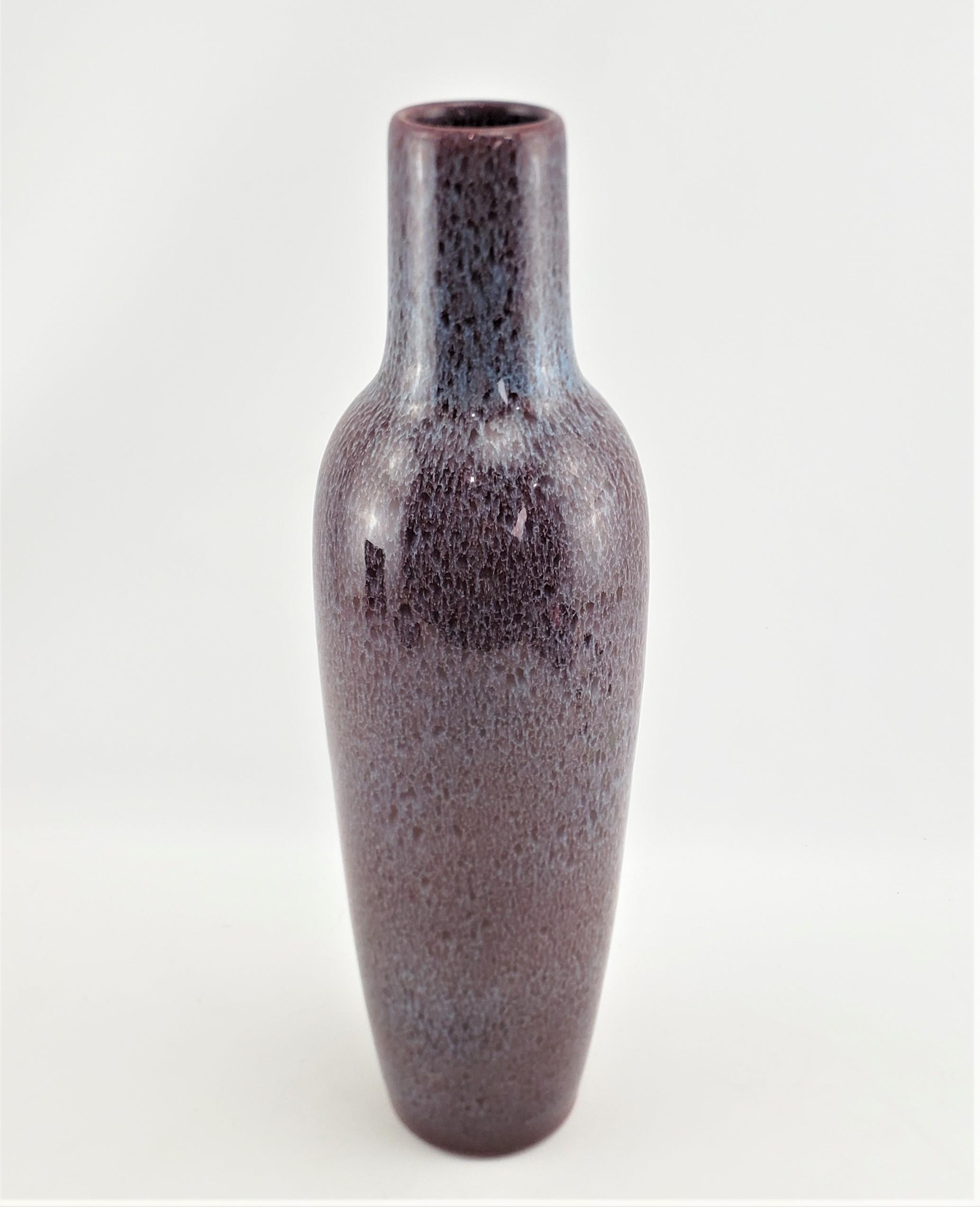 Ce grand vase en poterie d'art a été fabriqué par la célèbre usine de Bretby, en Angleterre, vers 1920, dans le style Art déco de l'époque. La forme élégante et effilée de ce vase mesure plus de 18 pouces de hauteur. Il a un fond bleu/vert et une