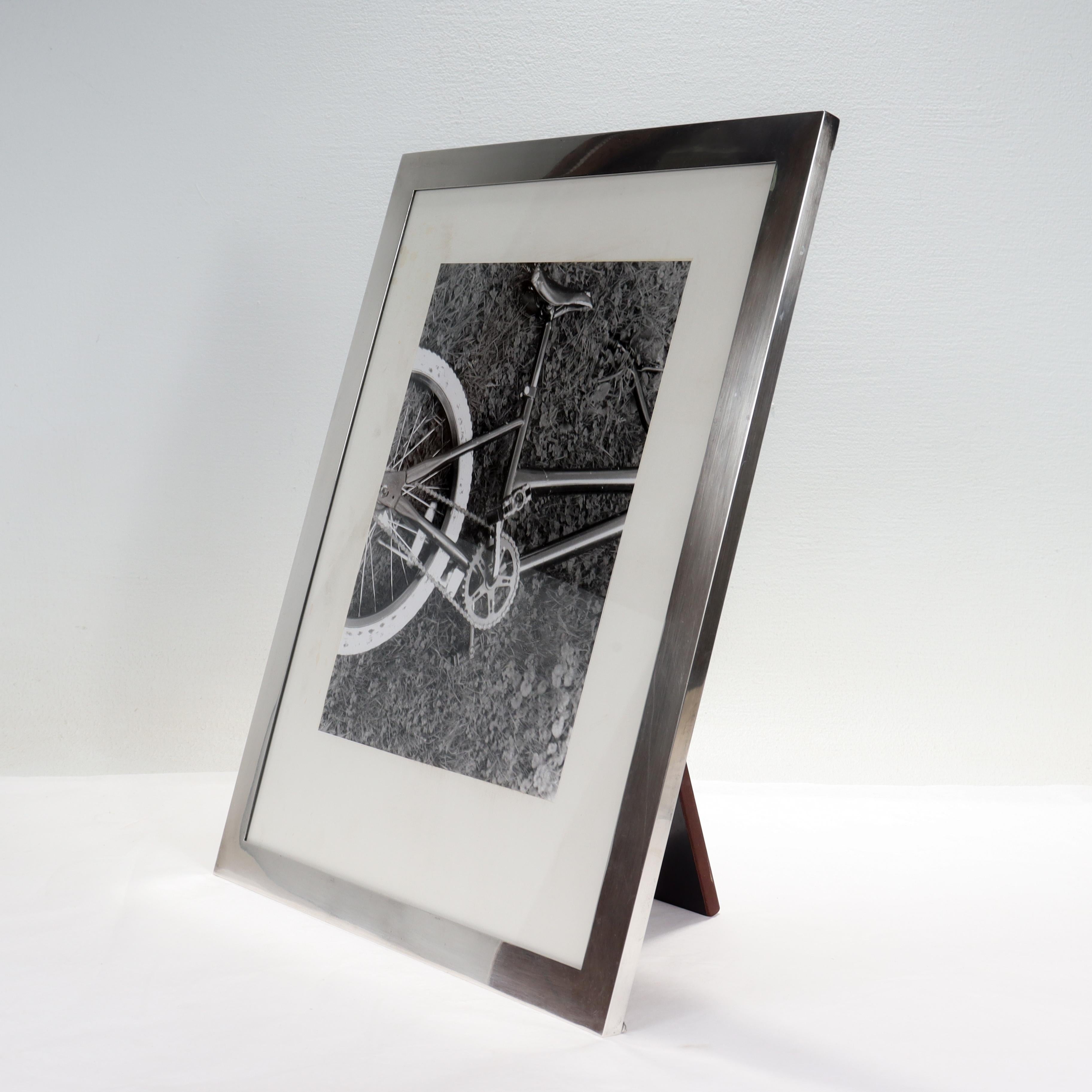 A large American Art Deco silver picture or photo frame.

In sterling silver.

By Lebkucher & Co. 

With a masonite easel back.

Marked to the base with Lebkucher's mark / Sterling / 3011 / Hand Made.

Simply a wonderful sterling silver picture
