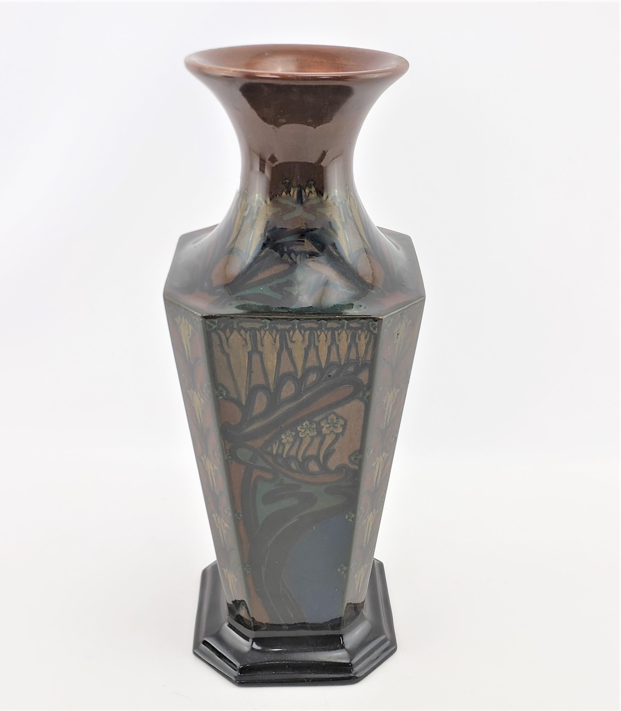 This large and substantial art pottery vase was made by the well known Rozenburg Porcelain factory of Holland in approximately 1900 in an Art Nouveau style. This eight sided vase is made of earthen ware and formed in a tapered eight sided vase