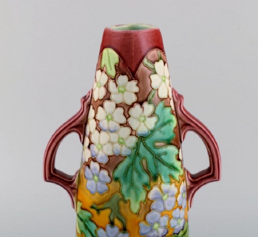 Large antique Art Nouveau vase with handles in glazed ceramics. 
Hand-painted flowers and foliage on a red background. Early 20th century.
Measures: 32 x 17.5 cm.
In excellent condition.
Stamped.