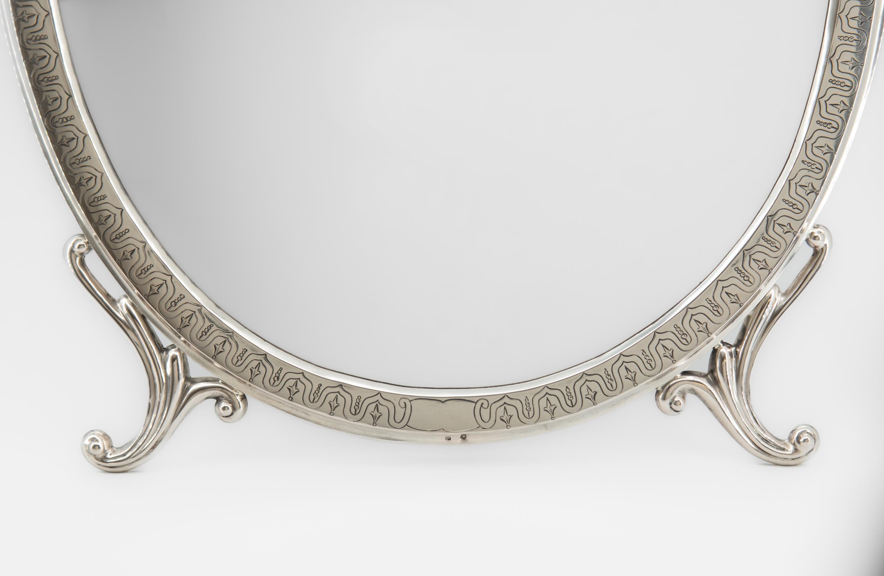 Antiker österreichischer 750er-Silberspiegel mit ovalem Strebenrahmen für den Frisiertisch. Wien - CIRCA 1890. Der Kopf der Diana in einem Kleeblatt auf dem Rahmen, flankiert von einer 4 und den Initialen des Herstellers.

Der ovale Spiegel hat
