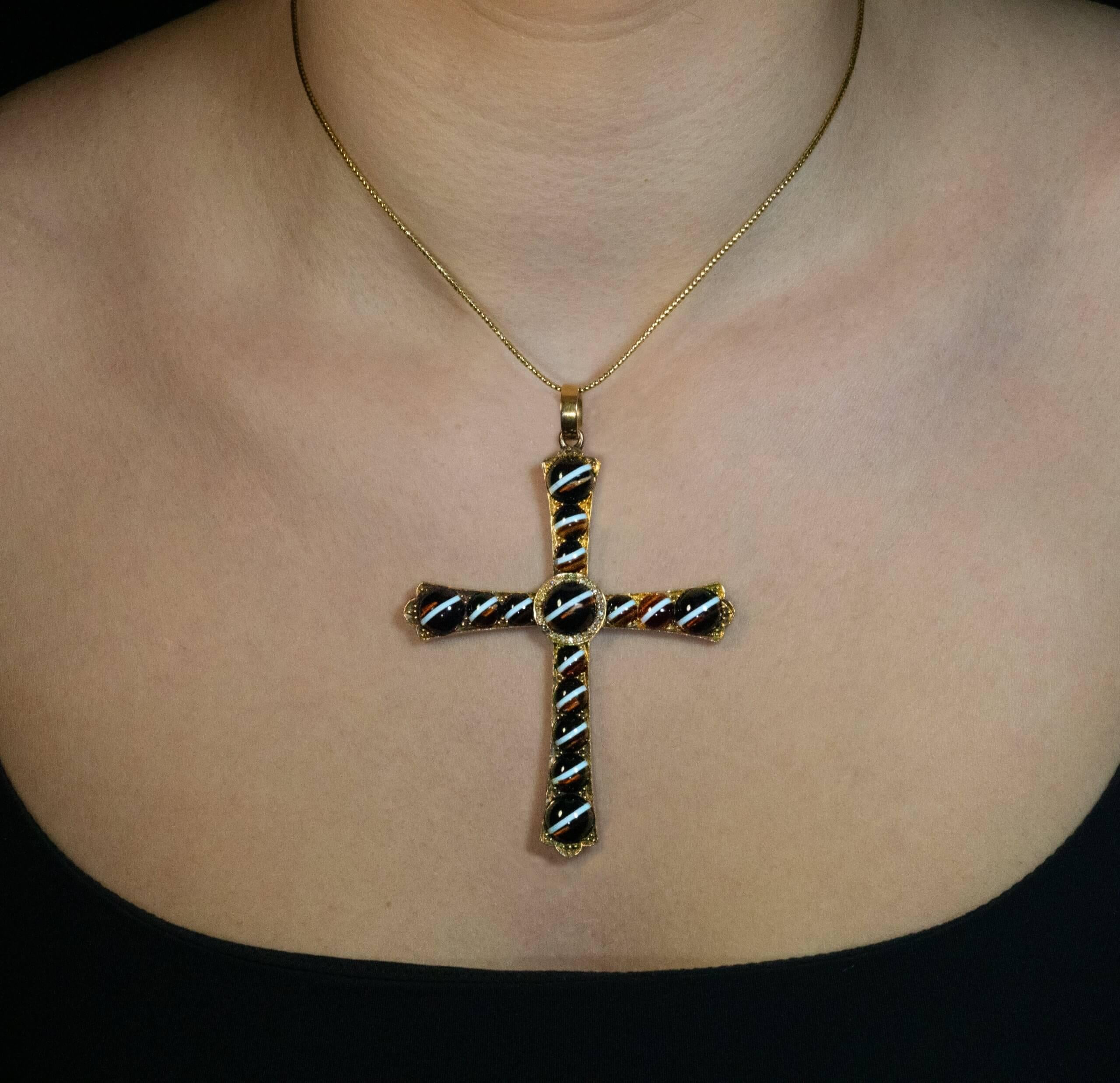 Circa 1880  
This unusual, one of a kind cross pendant is finely crafted in 14K gold. It is set with fifteen perfectly matched cabochon cut banded agates. The center stone is encircled by old rose cut diamonds.  The cross measures (without bail) 84