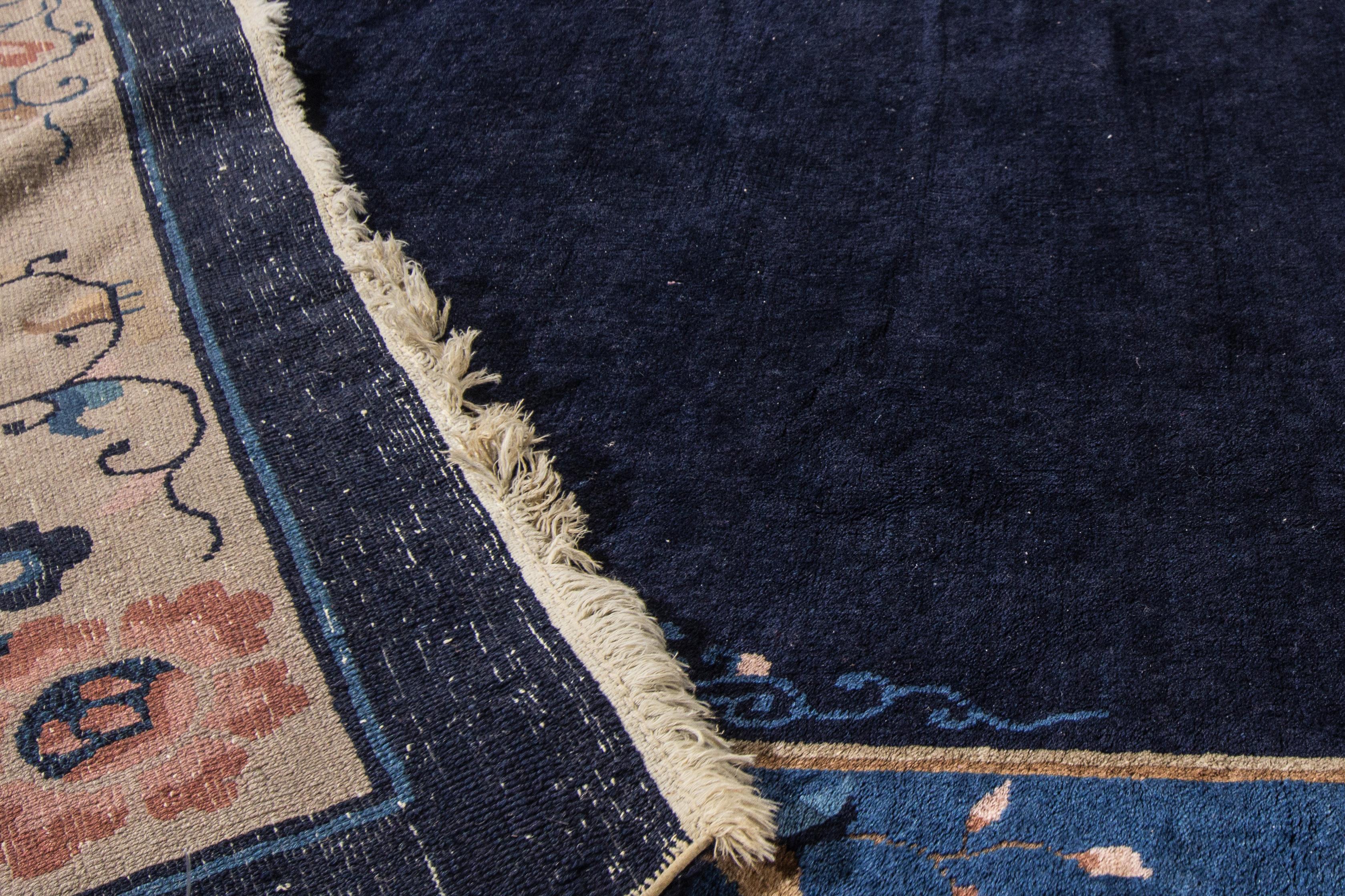 A beautiful oversize antique Chinese Art Deco hand knotted wool rug with a navy- blue field. This rug has a frame of beige and multi-color accents all over Chinese floral design.

This rug measures: 11'6