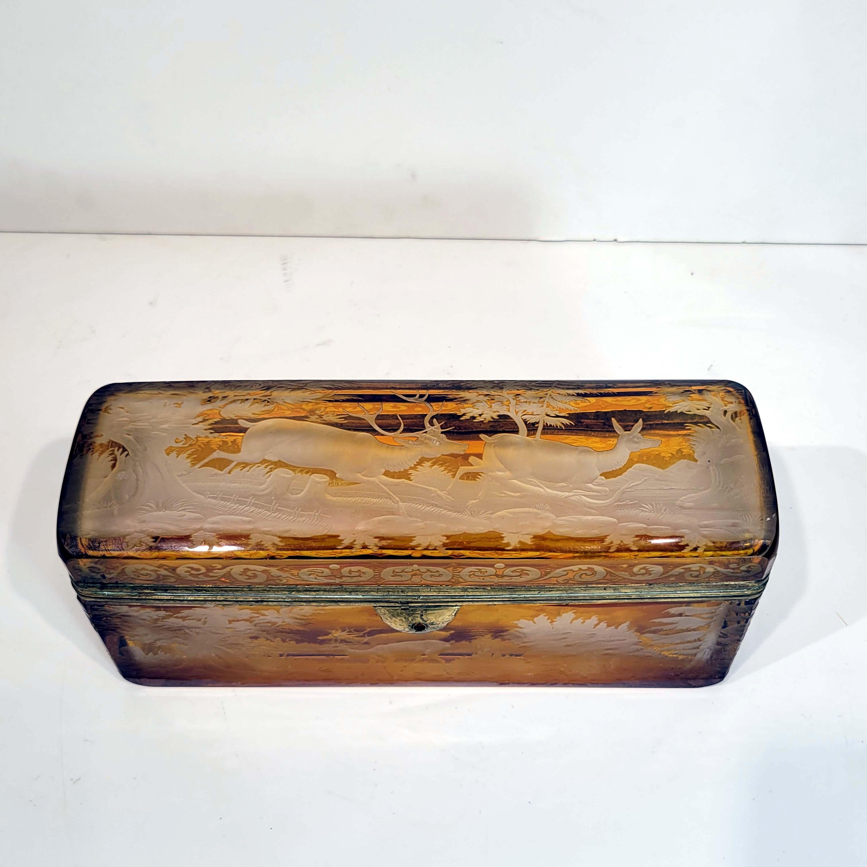 A stunning and rare 19th century Bohemian intaglio cut to clear footed casket, perfect for storing letters on your writing desk or place among your collection for all to see. This large amber box is one huge intaglio cut hunting scene displaying the