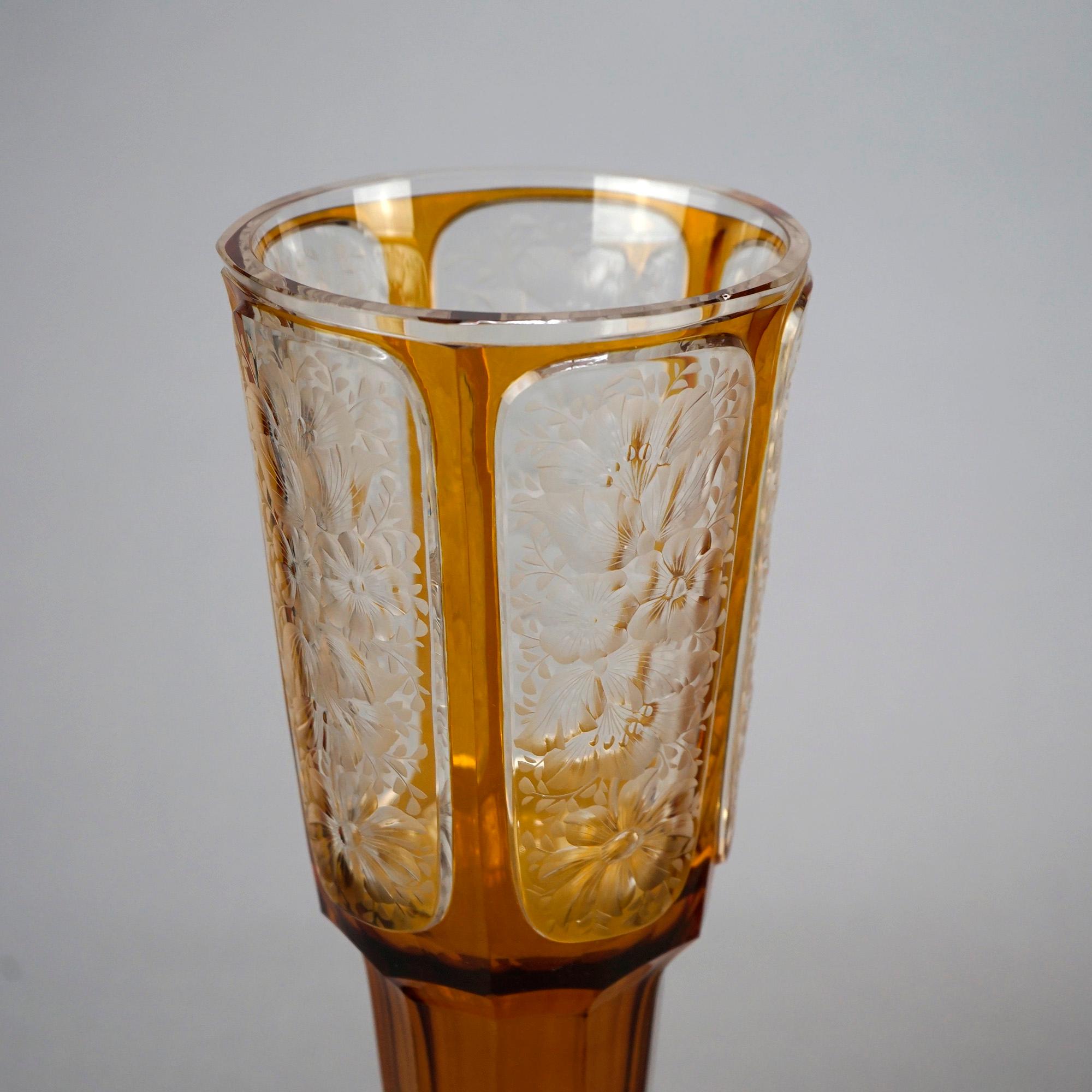 Paire de vases de Bohème surdimensionnés et anciens, de la manière de Moser, offrant une construction en verre d'art avec des vaisseaux ambrés évasés ayant des panneaux découpés et transparents avec des motifs floraux gravés, reposant sur des bases