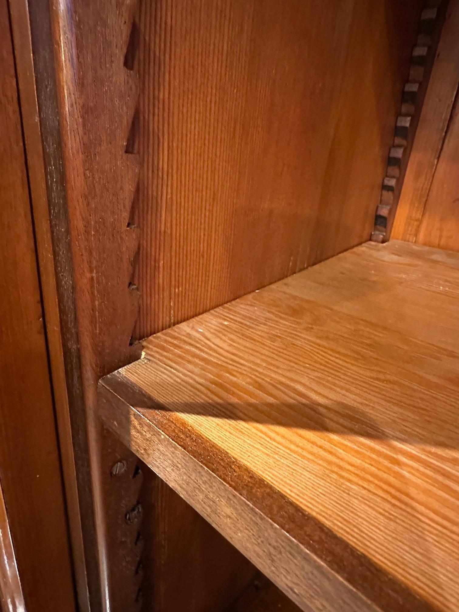 Impressive antique mahogany bookcase. In completely original condition. Beautiful warm weathered mahogany color. The cabinet has 8 parts with adjustable shelves. Behind each glass door are 3 adjustable shelves. Behind each closed door is 1