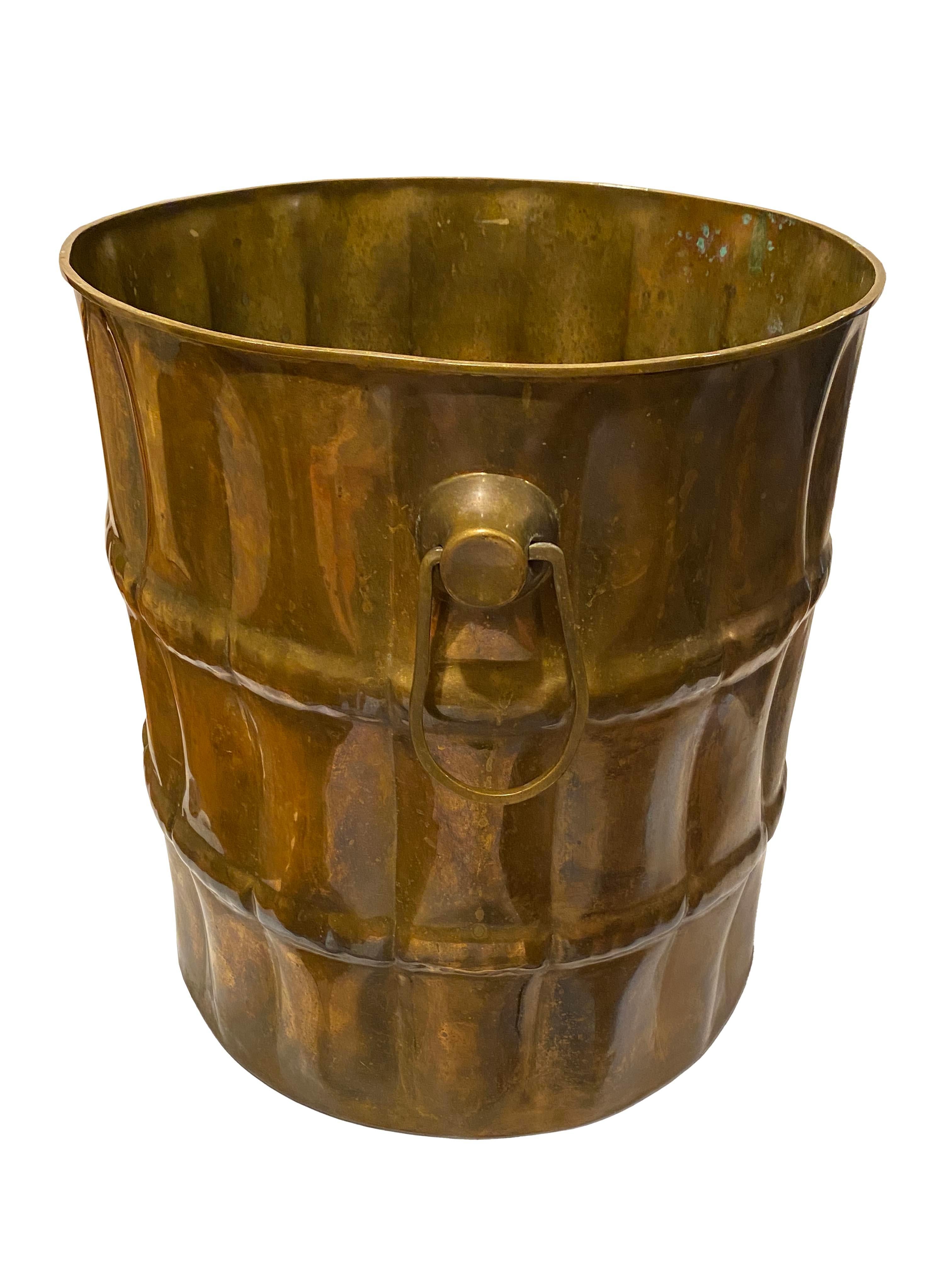 Cette grande jardinière en laiton antique est une pièce substantielle et intemporelle. Sa forme classique et utilitaire est accentuée par une patine magnifiquement vieillie, qui lui confère un caractère riche et un ton chaud et doré que seul le