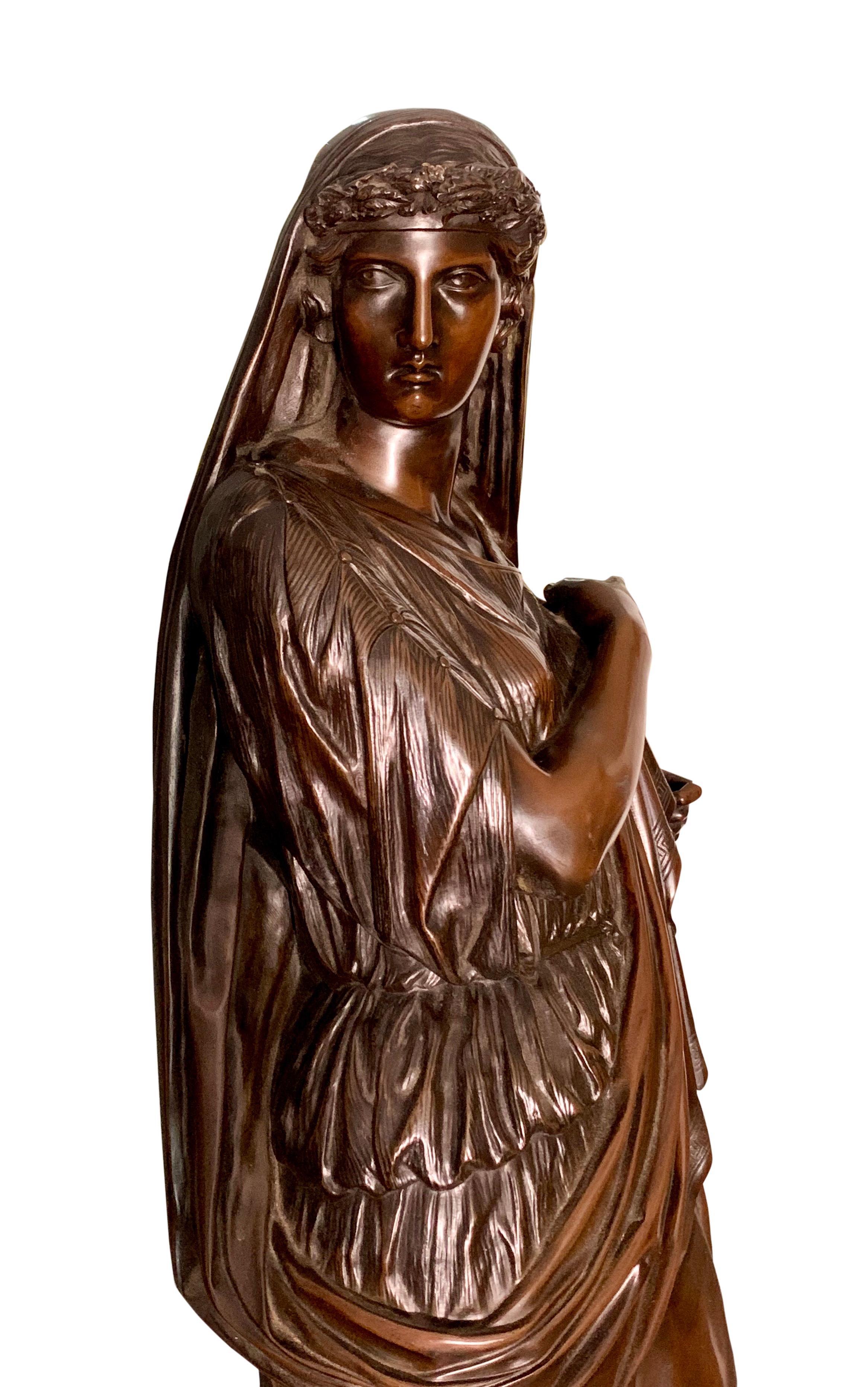 Eine schöne französische patinierte Bronzefigur aus dem 19. Jahrhundert, die eine stehende, drapierte klassische Frau mit einem Kranz im Haar darstellt, die eine Urne hält.
Titel: Antifonh

Maßnahmen: 
Höhe 41,5